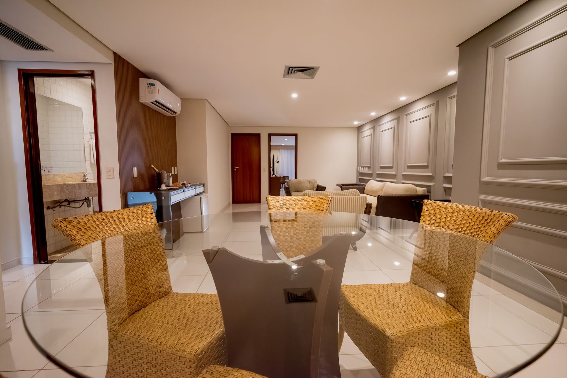 Uma sala de jantar com mesa e cadeiras de vidro