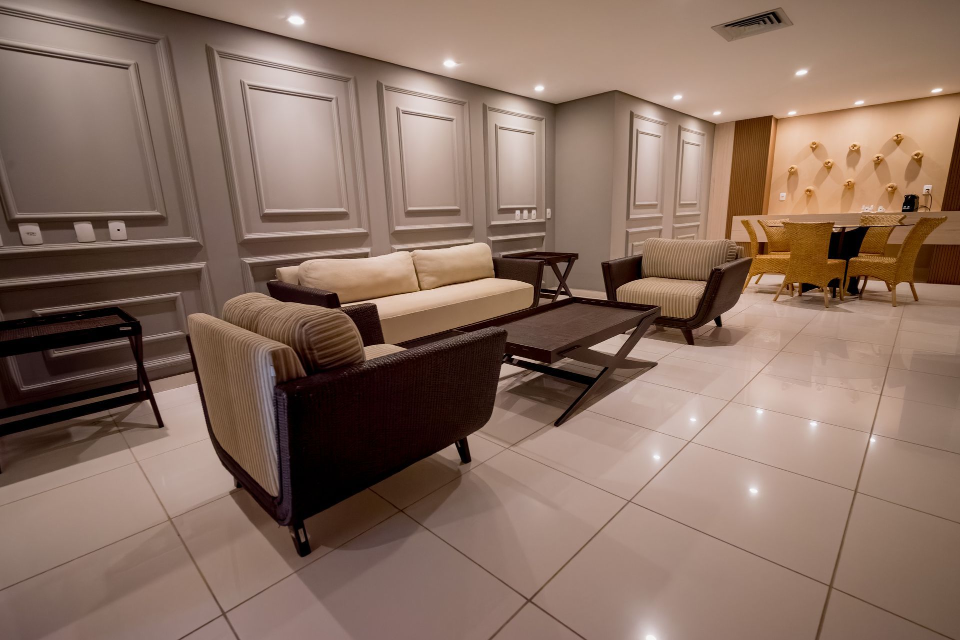 Uma sala de estar com um sofá, cadeiras e uma mesa de centro.