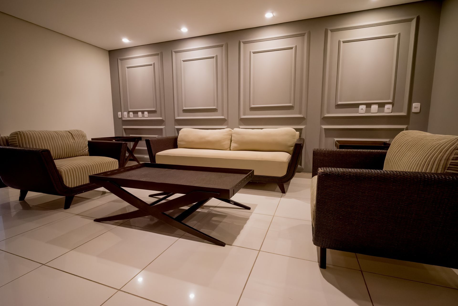 Uma sala de estar com um sofá, cadeiras e uma mesa de centro
