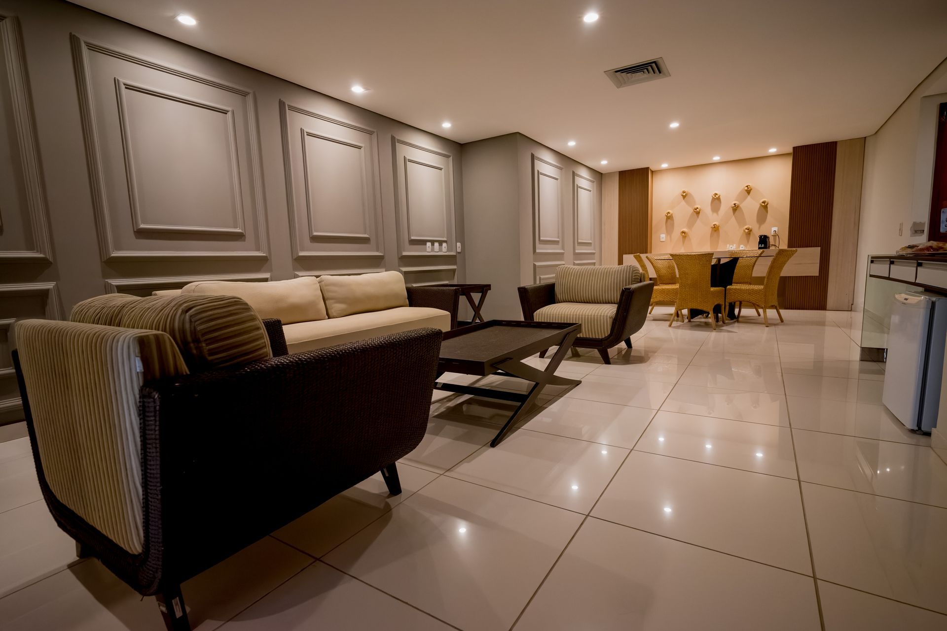 Uma sala de estar com um sofá, cadeiras e uma mesa.