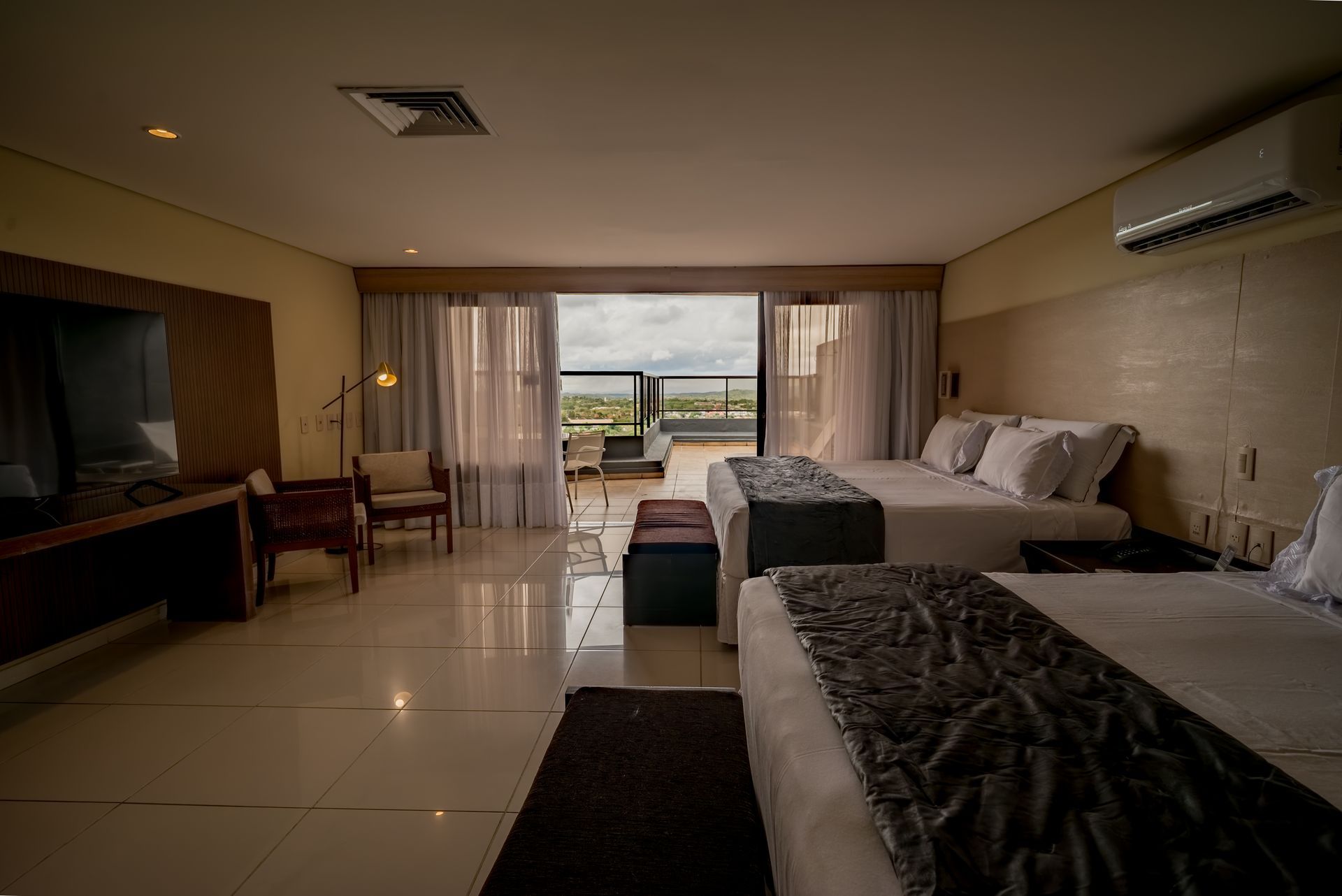 Um quarto de hotel com duas camas e uma varanda.
