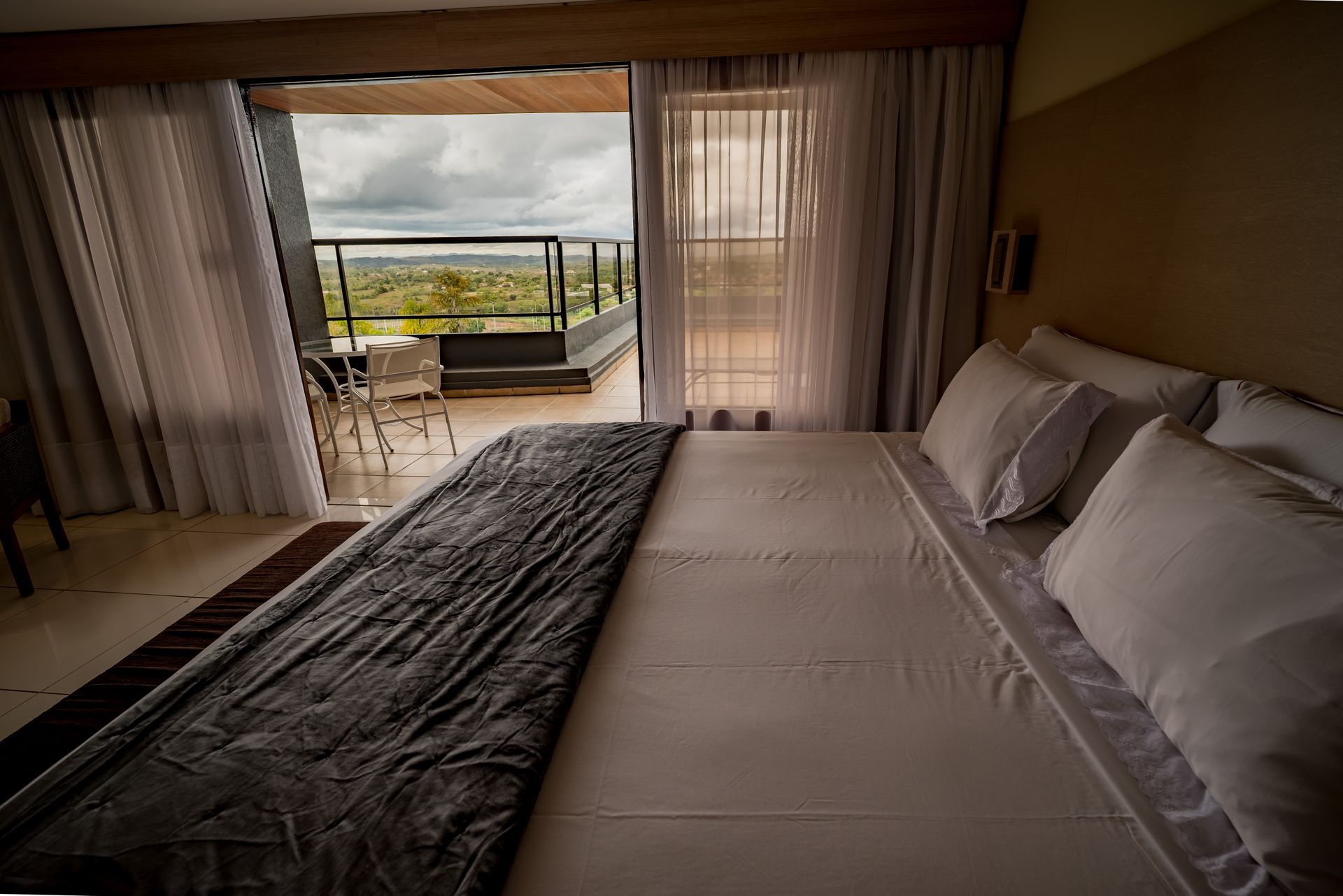 Um quarto de hotel com uma cama king size e uma varanda.