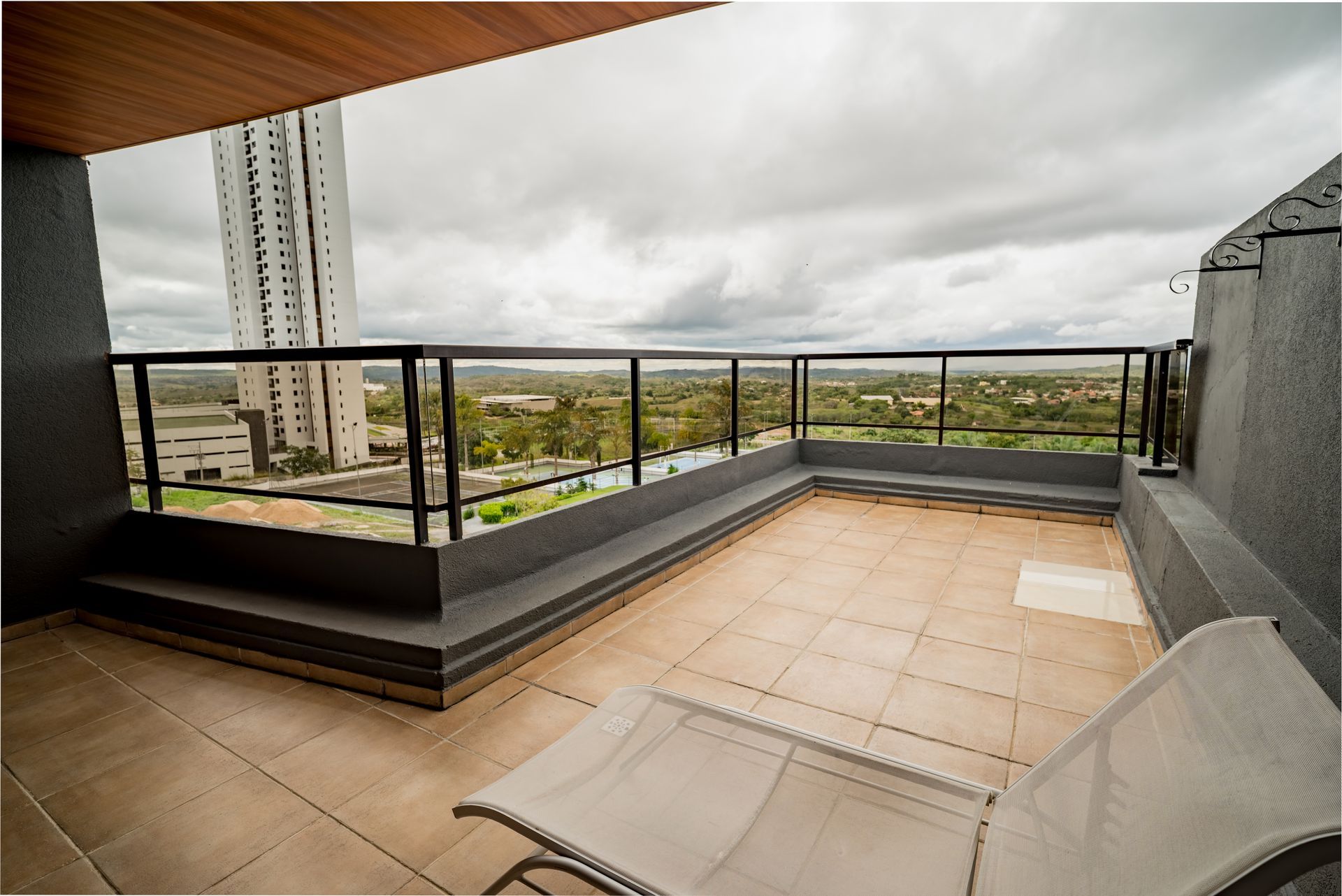 Uma varanda com uma cadeira e vista para uma cidade
