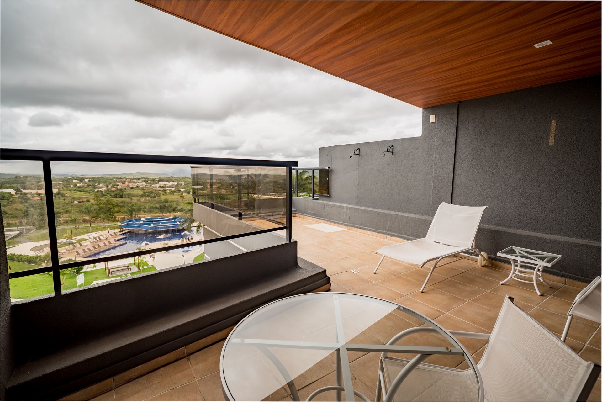Uma varanda com mesa e cadeiras e vista para a cidade.