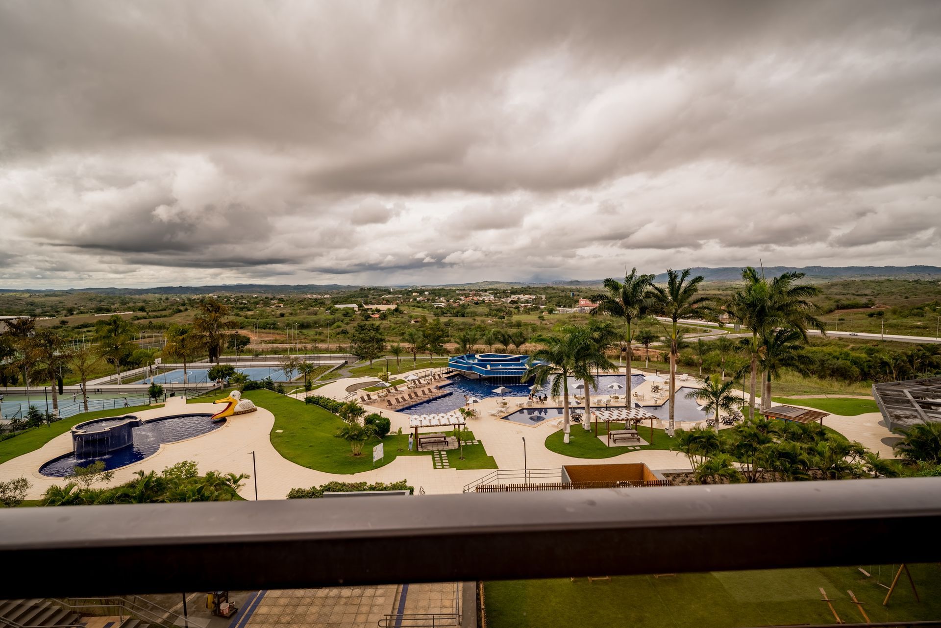Uma vista de um parque aquático de uma varanda em um dia nublado.