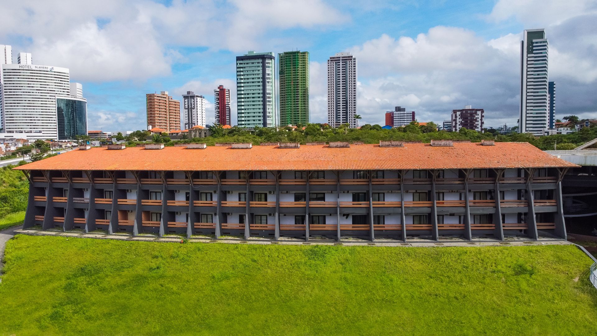 Uma vista aérea de um grande edifício com o horizonte da cidade ao fundo