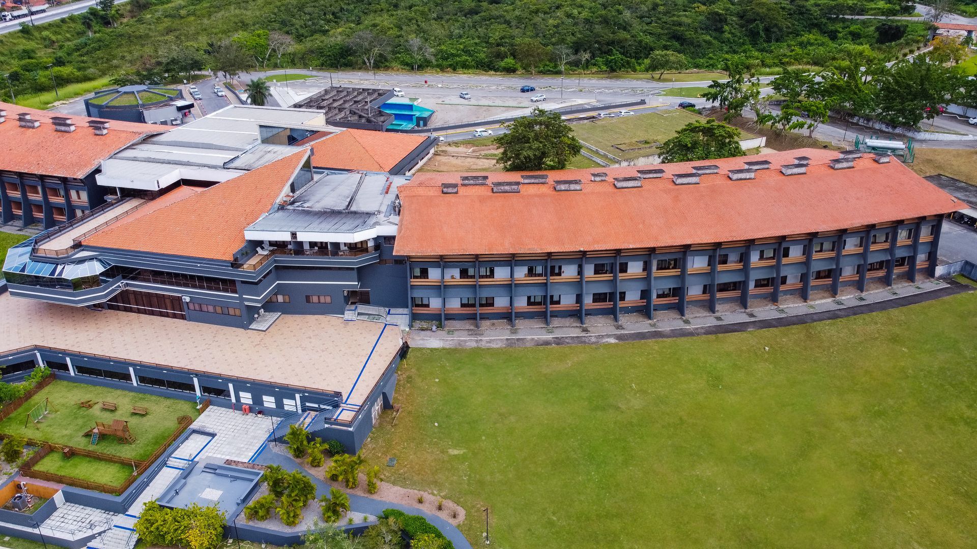 Uma vista aérea de um grande edifício com telhado de telha vermelha