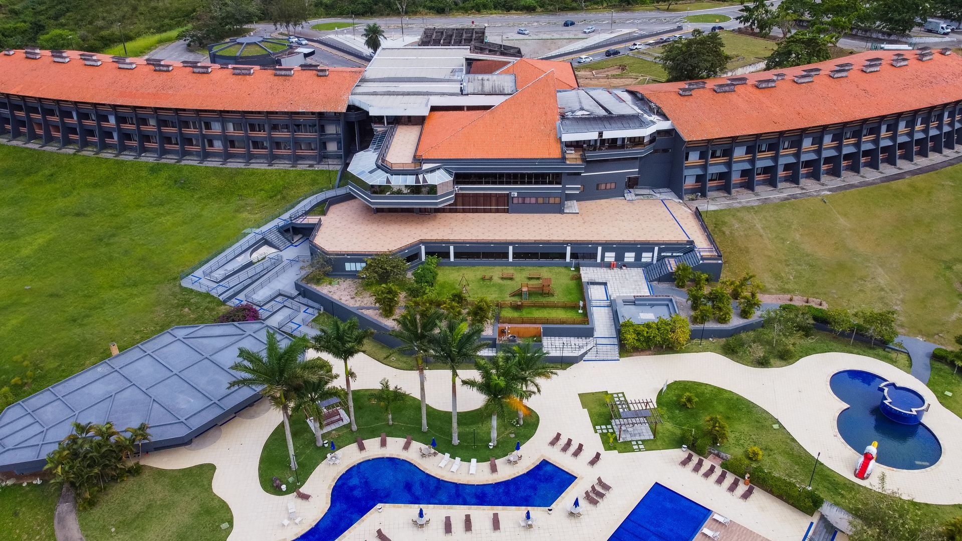 Uma vista aérea de um grande edifício com uma piscina na frente.
