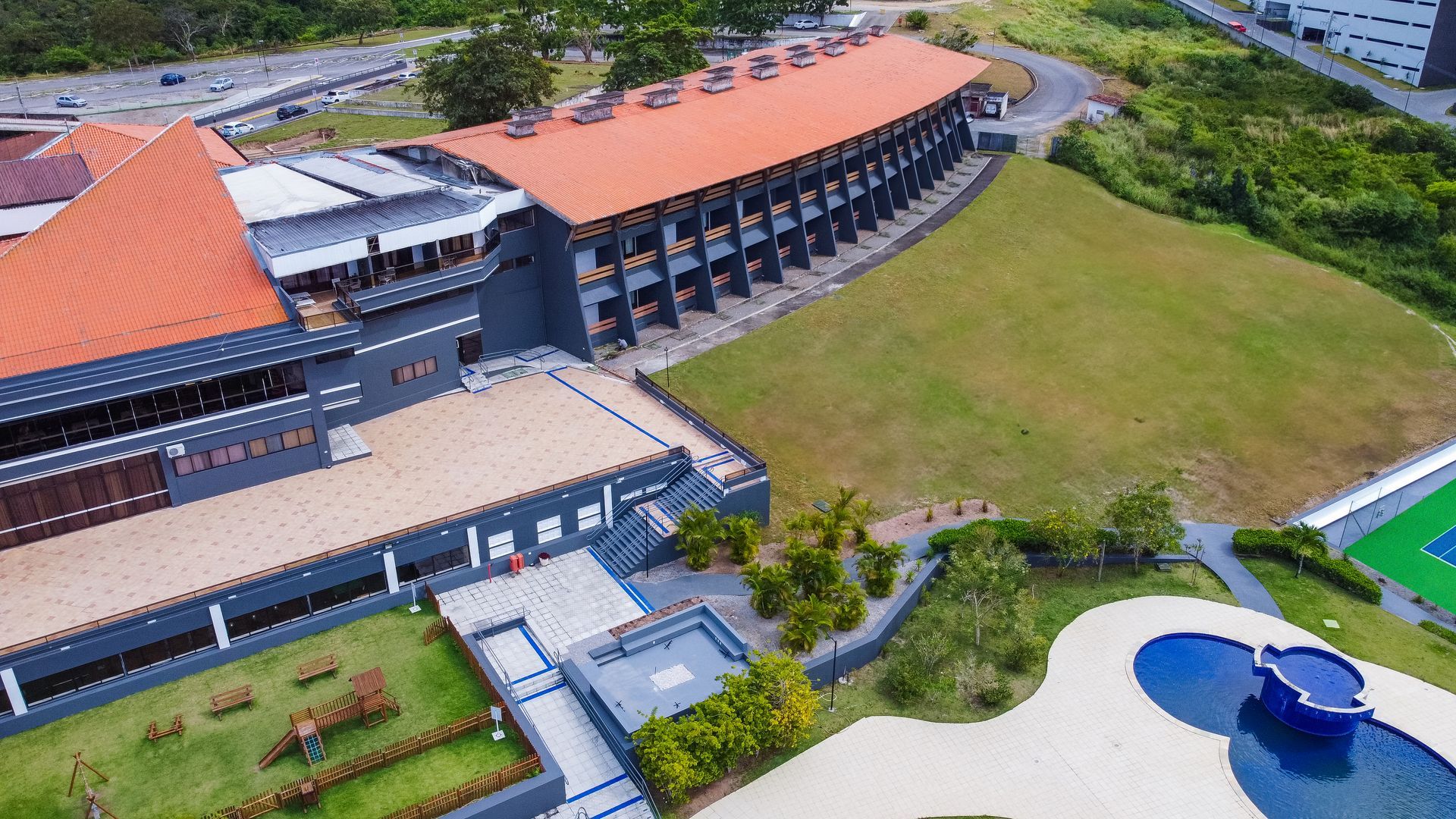 Uma vista aérea de um grande edifício com uma piscina na frente.