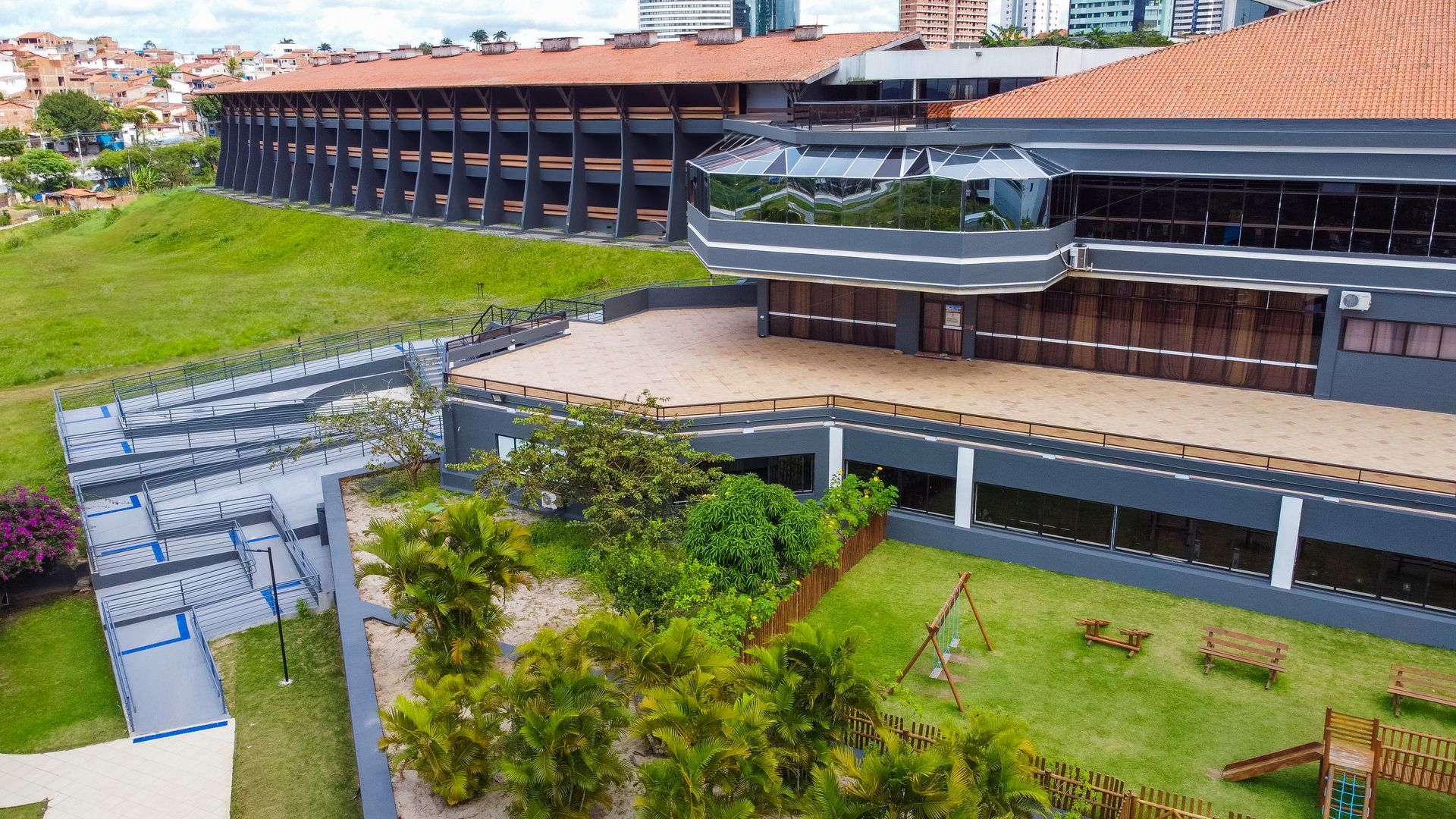 Uma vista aérea de um grande edifício com um playground na frente.