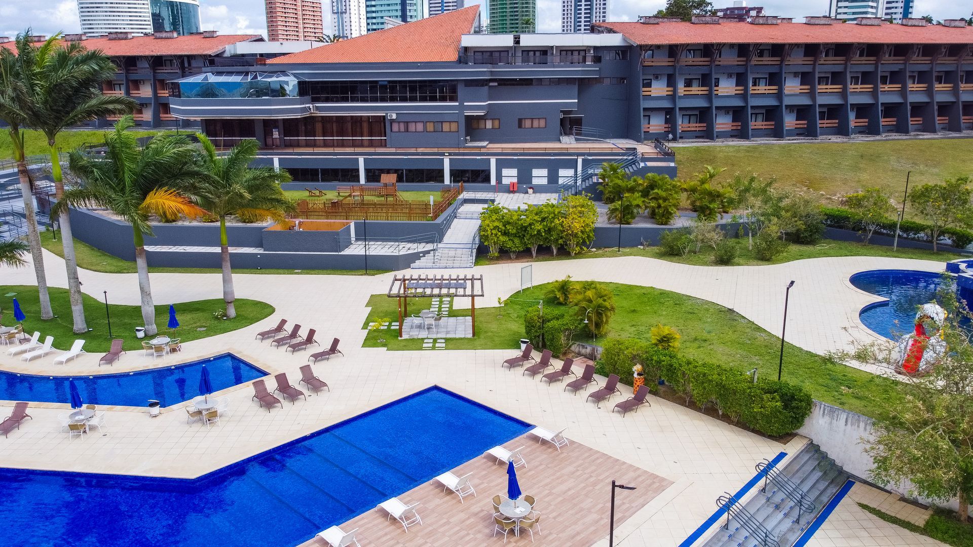 Uma vista aérea de uma grande piscina em frente a um grande edifício.