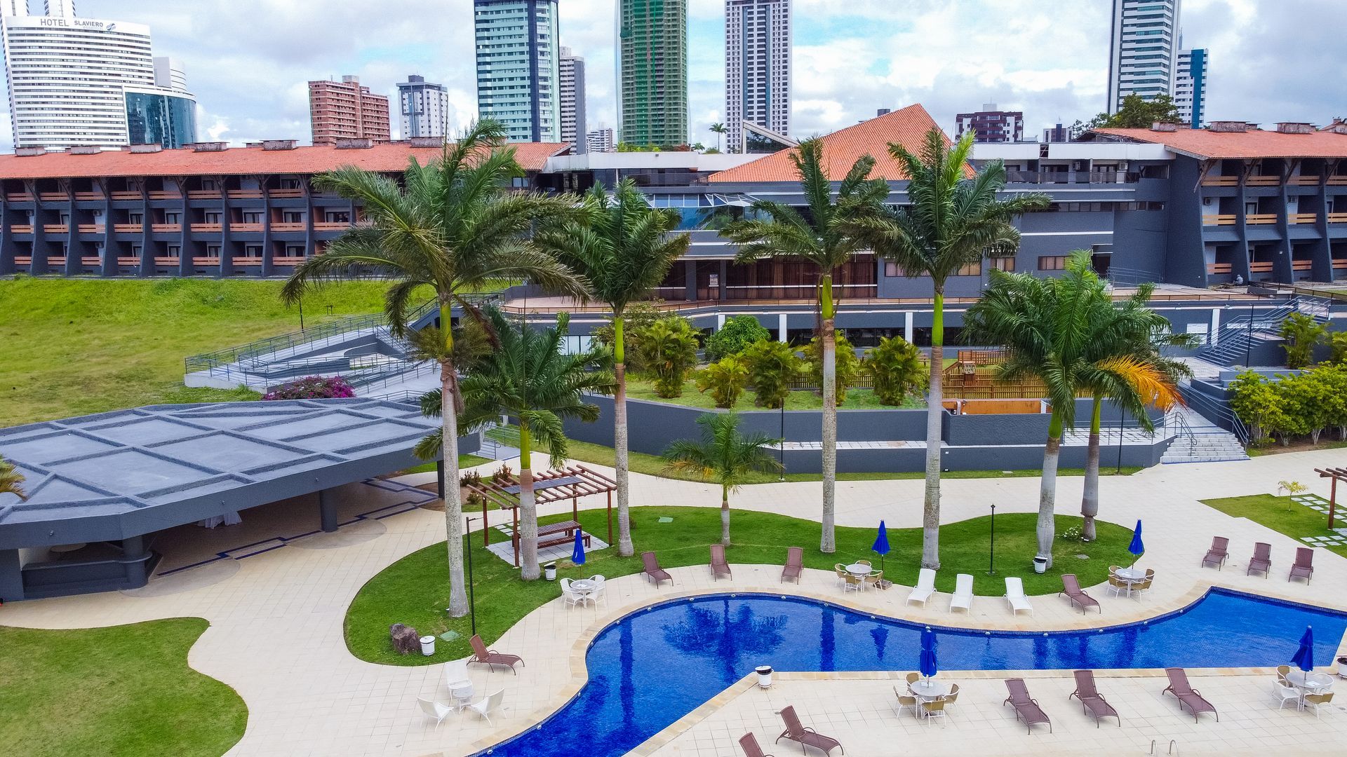 Uma vista aérea de uma grande piscina cercada por palmeiras.