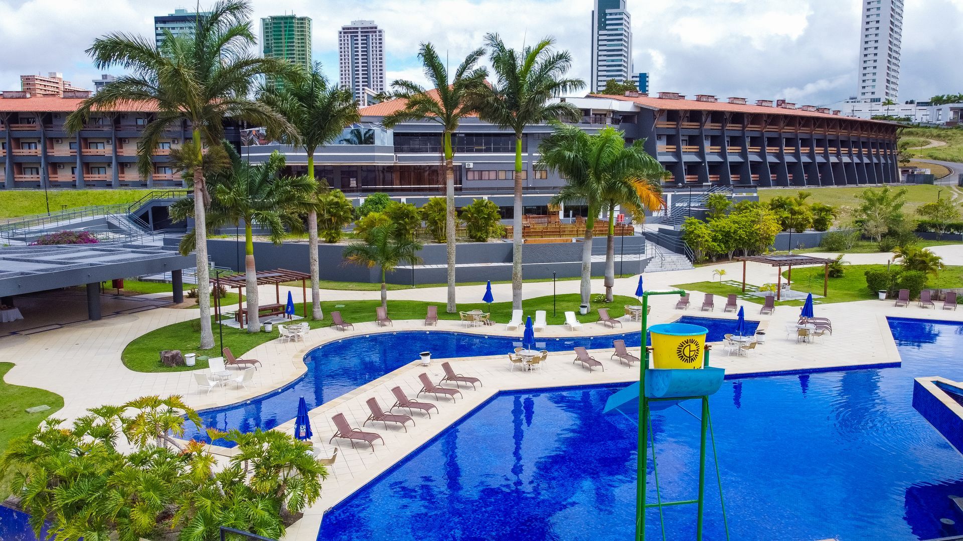 Uma vista aérea de uma grande piscina cercada por palmeiras.