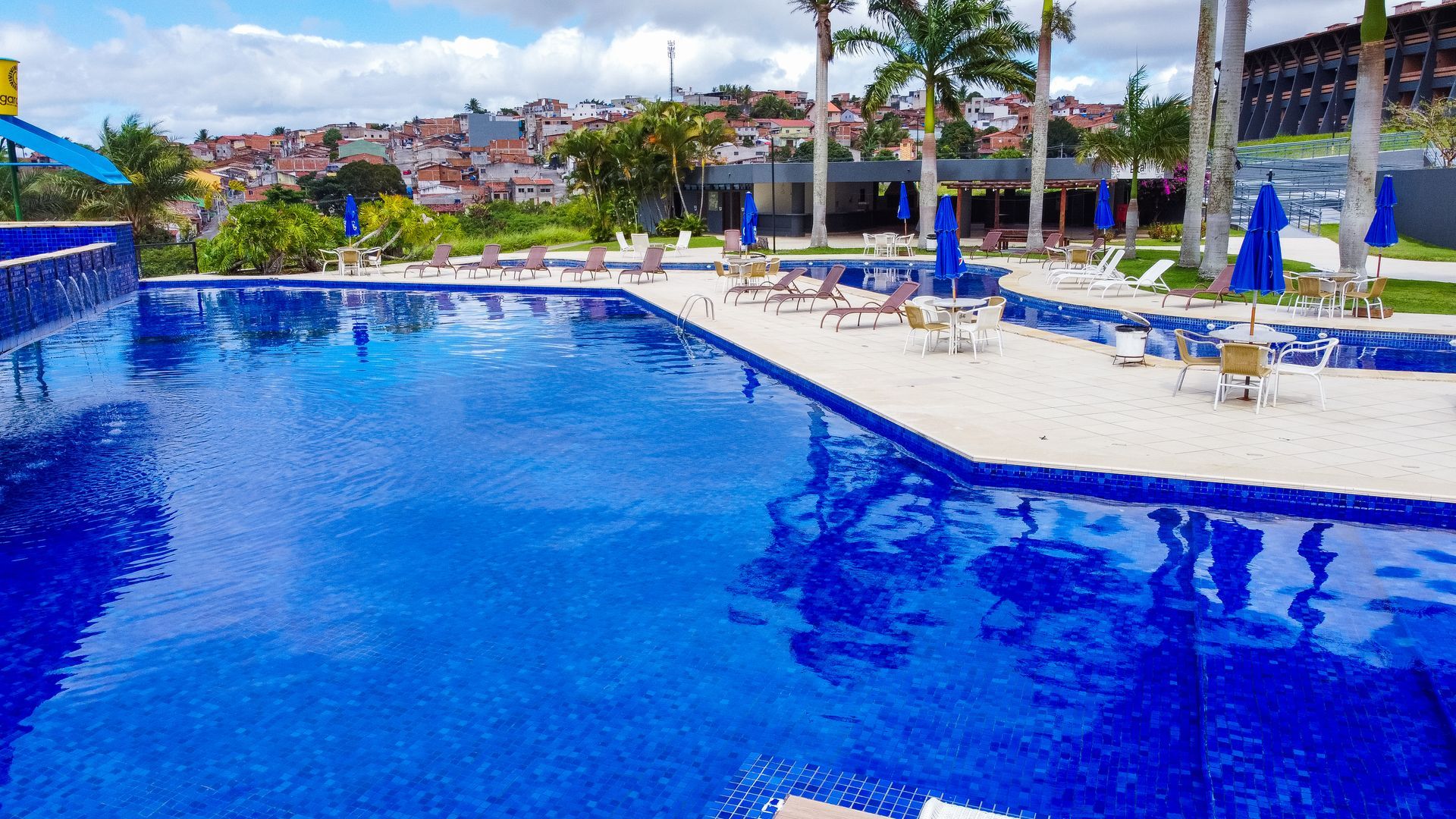 Uma grande piscina cercada por cadeiras e guarda-sóis.