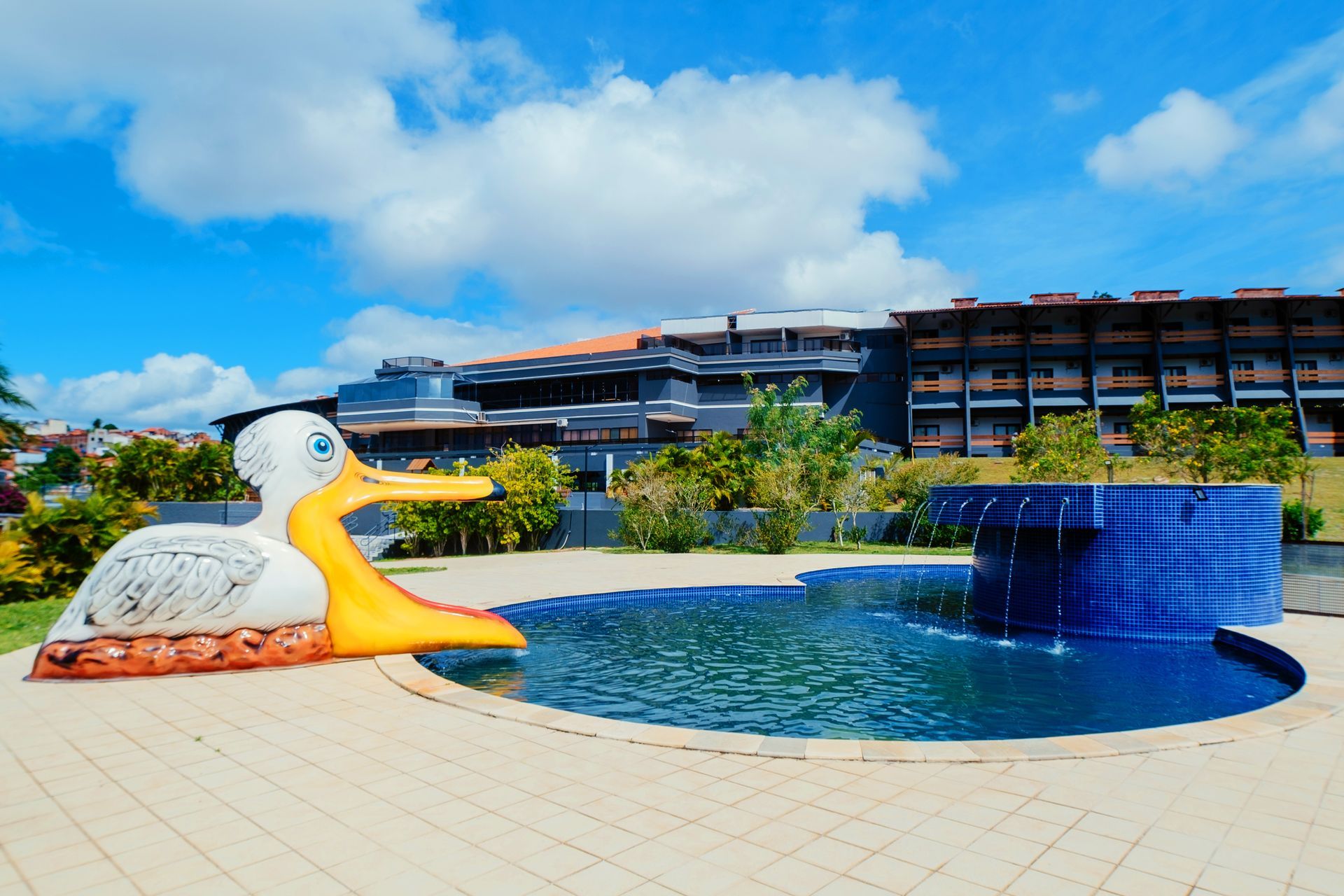 Um grande pato inflável está sentado ao lado de uma piscina.