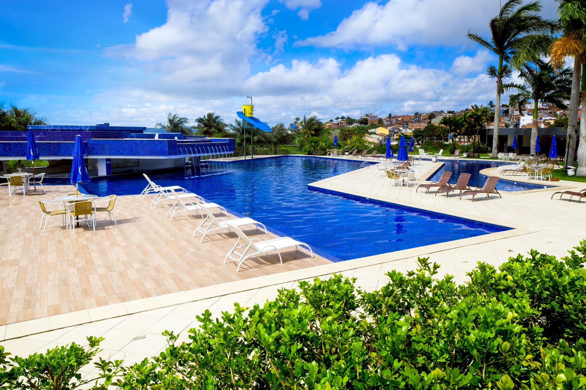 Uma grande piscina cercada por cadeiras e mesas