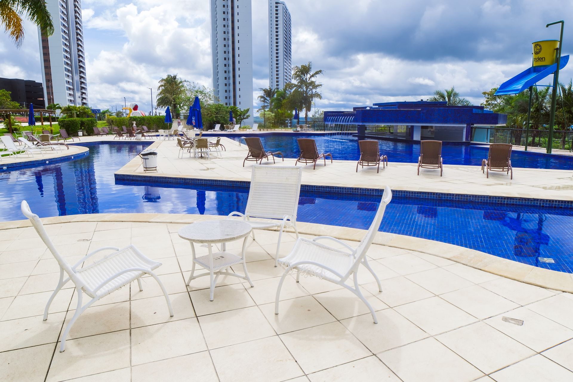 Uma piscina com cadeiras e uma mesa na frente