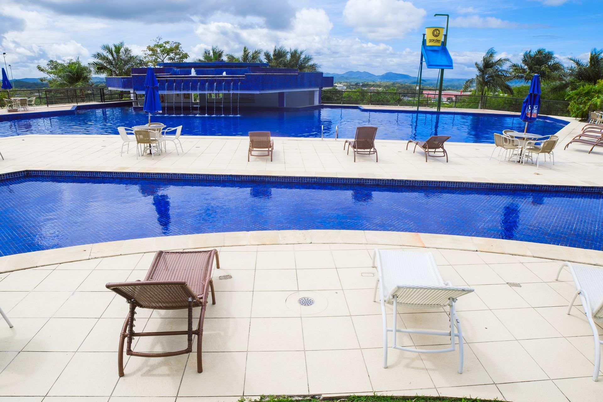 Uma grande piscina com cadeiras e mesas ao redor