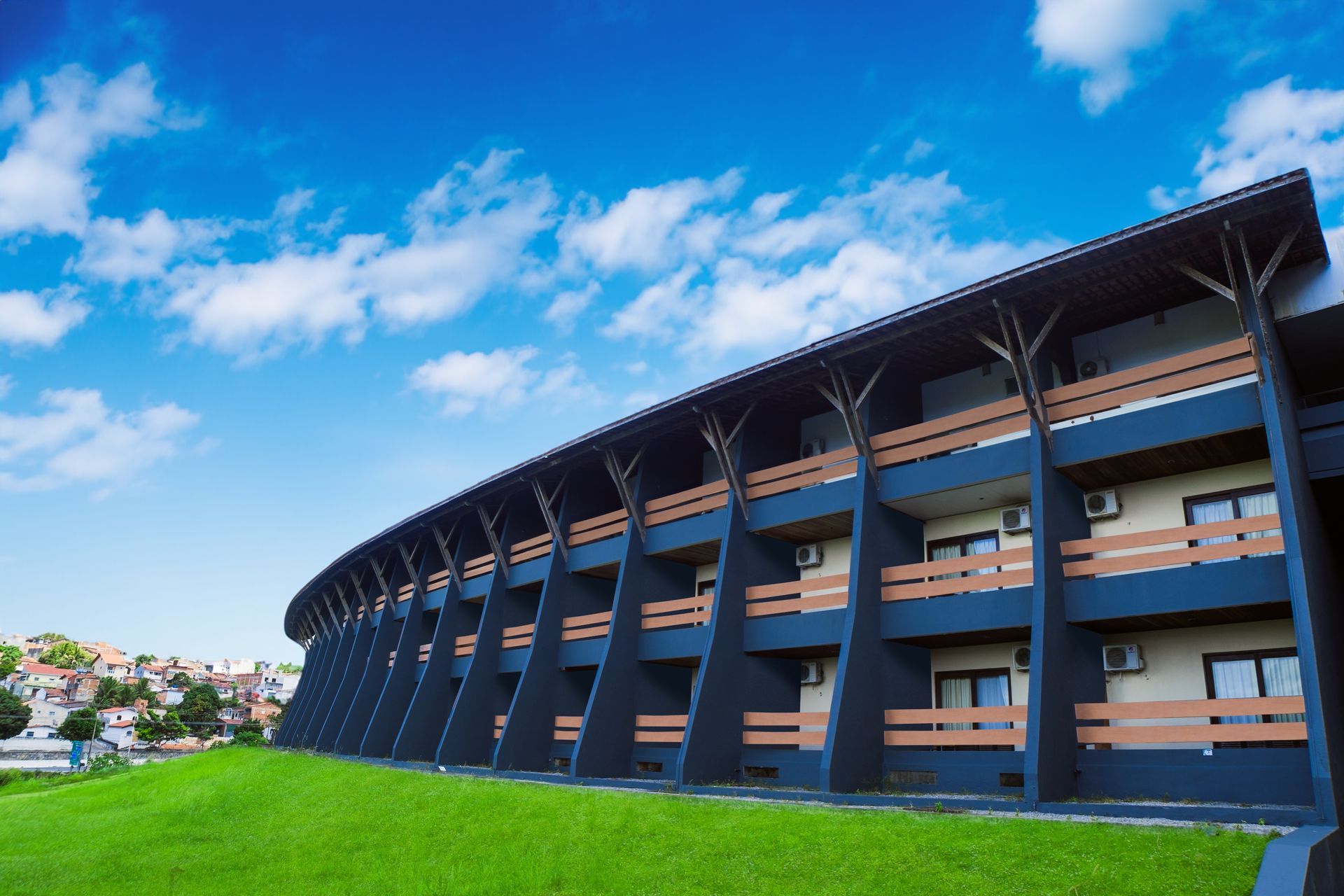 Um grande edifício com muitas varandas e um céu azul ao fundo.