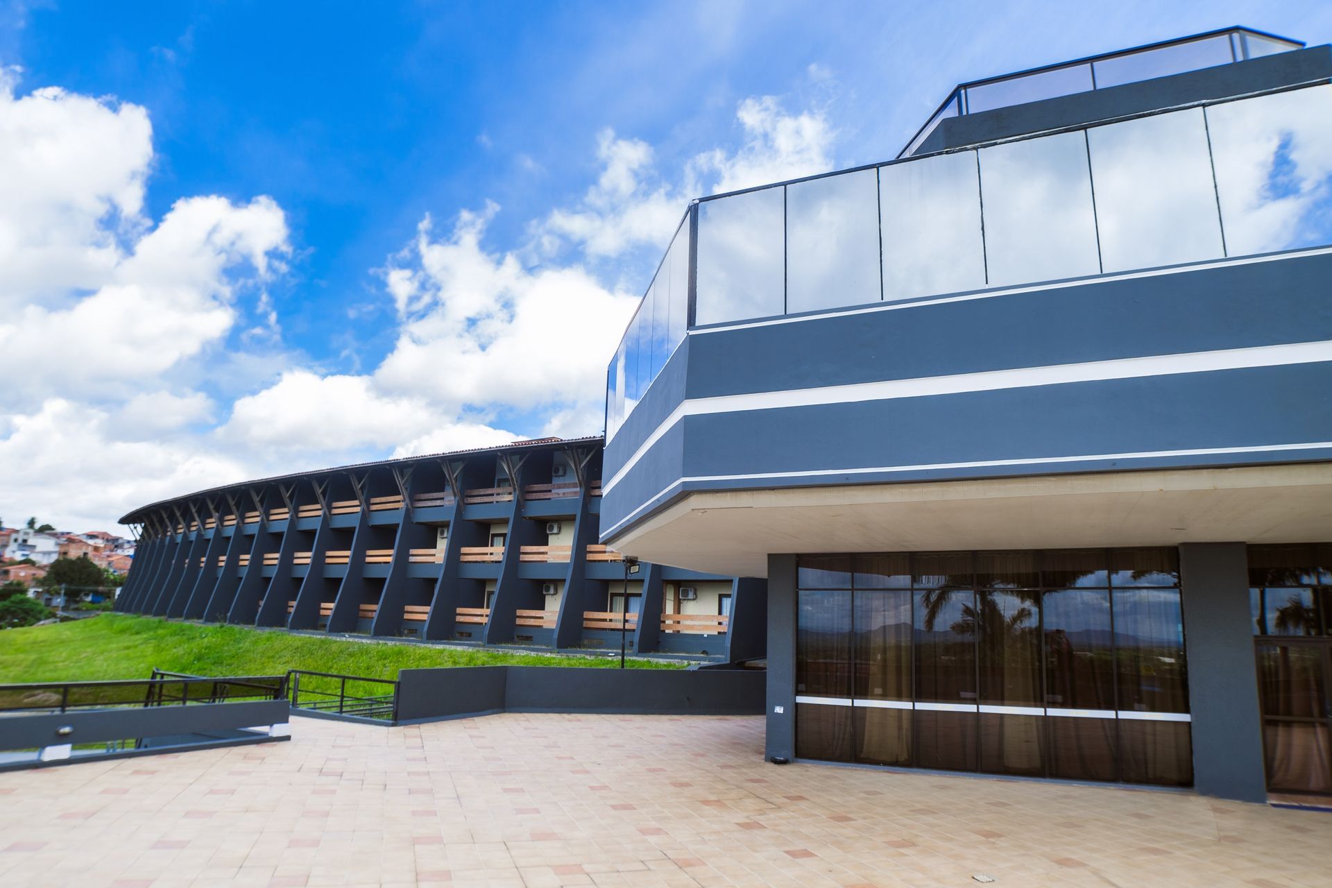 Um grande edifício com uma varanda e um céu azul ao fundo.