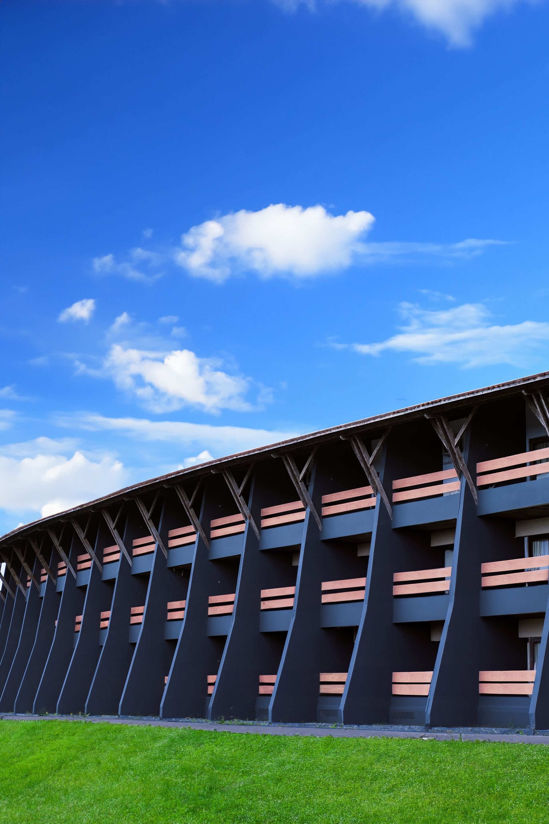 Um grande edifício com varandas e um céu azul ao fundo