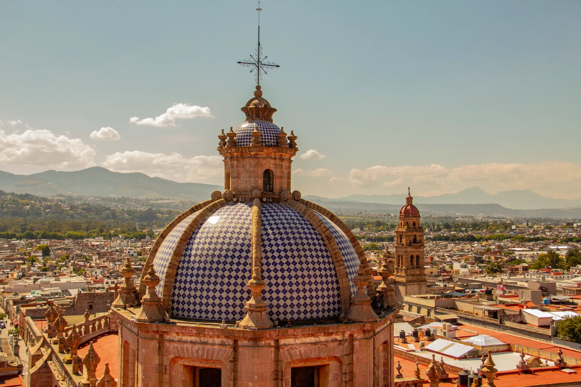 An aerial view of a church with a dome and a cross on top of it.