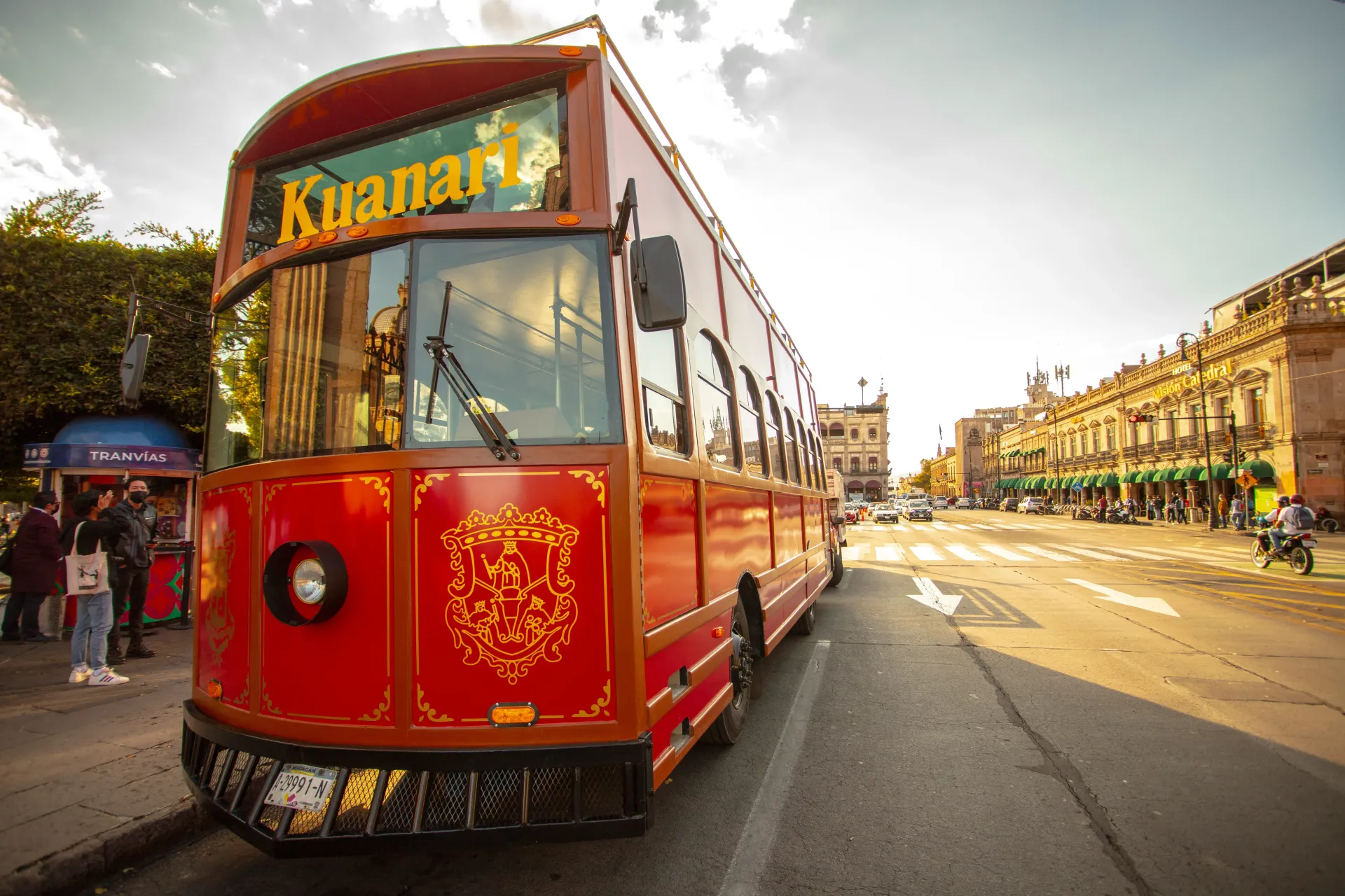 A red double decker bus is parked on the side of the road.