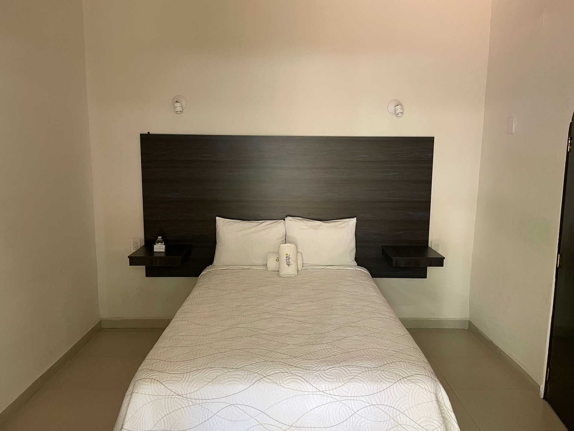 There is a bed in the middle of the room with a wooden headboard.