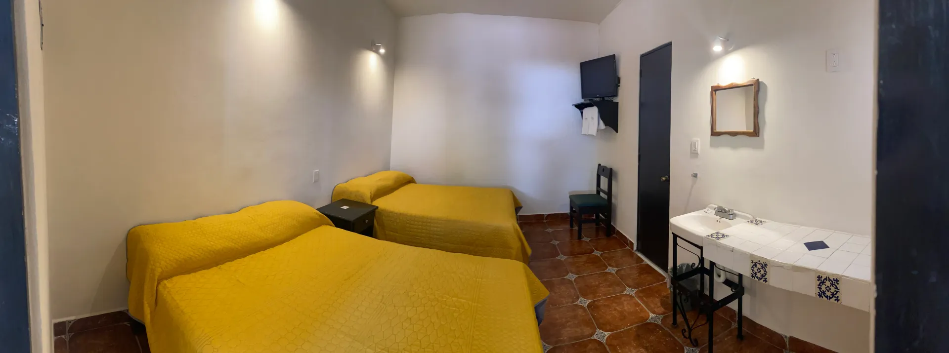 Una habitación de hotel con tres camas y un escritorio.