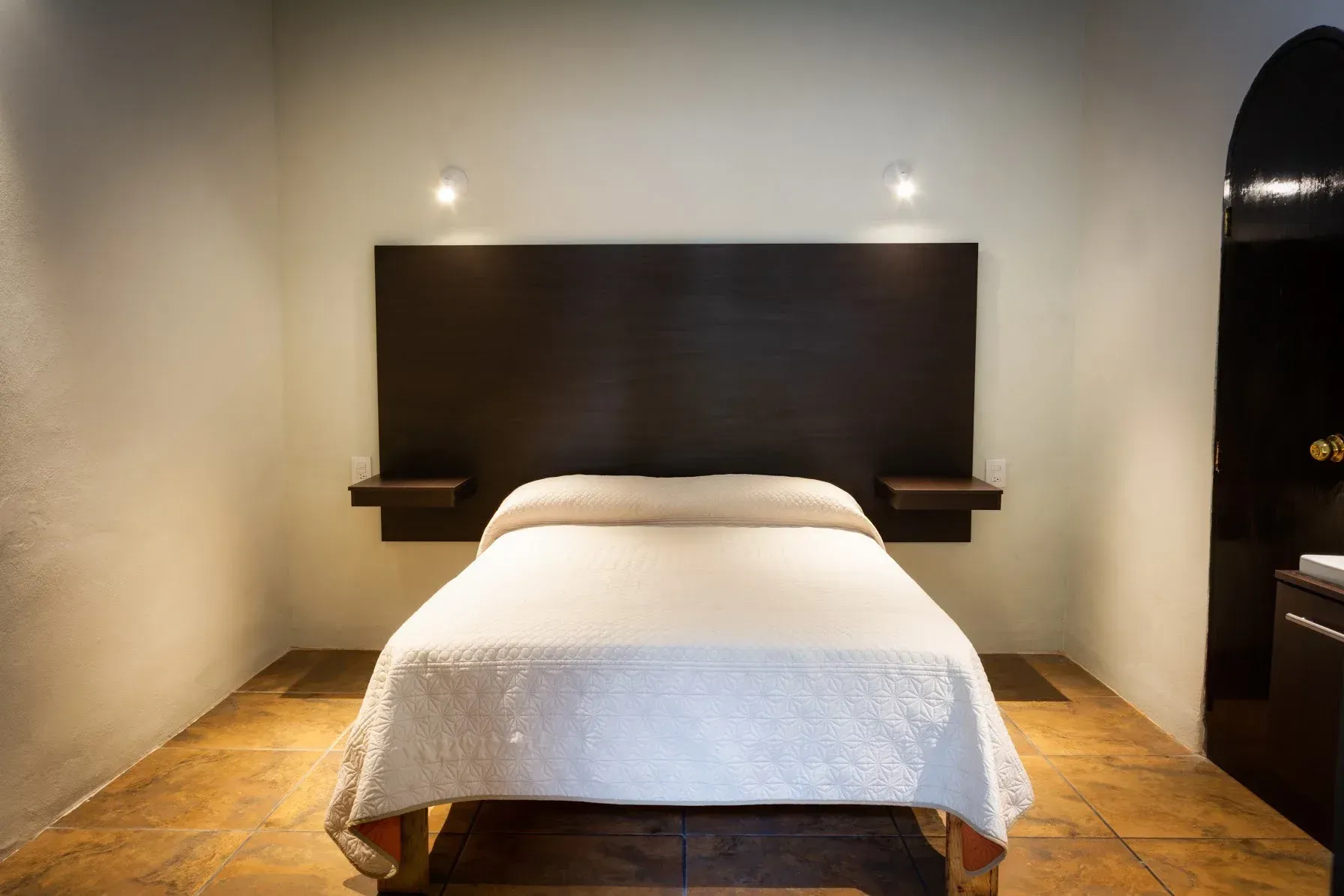 A bedroom with a bed , nightstands , and a door.