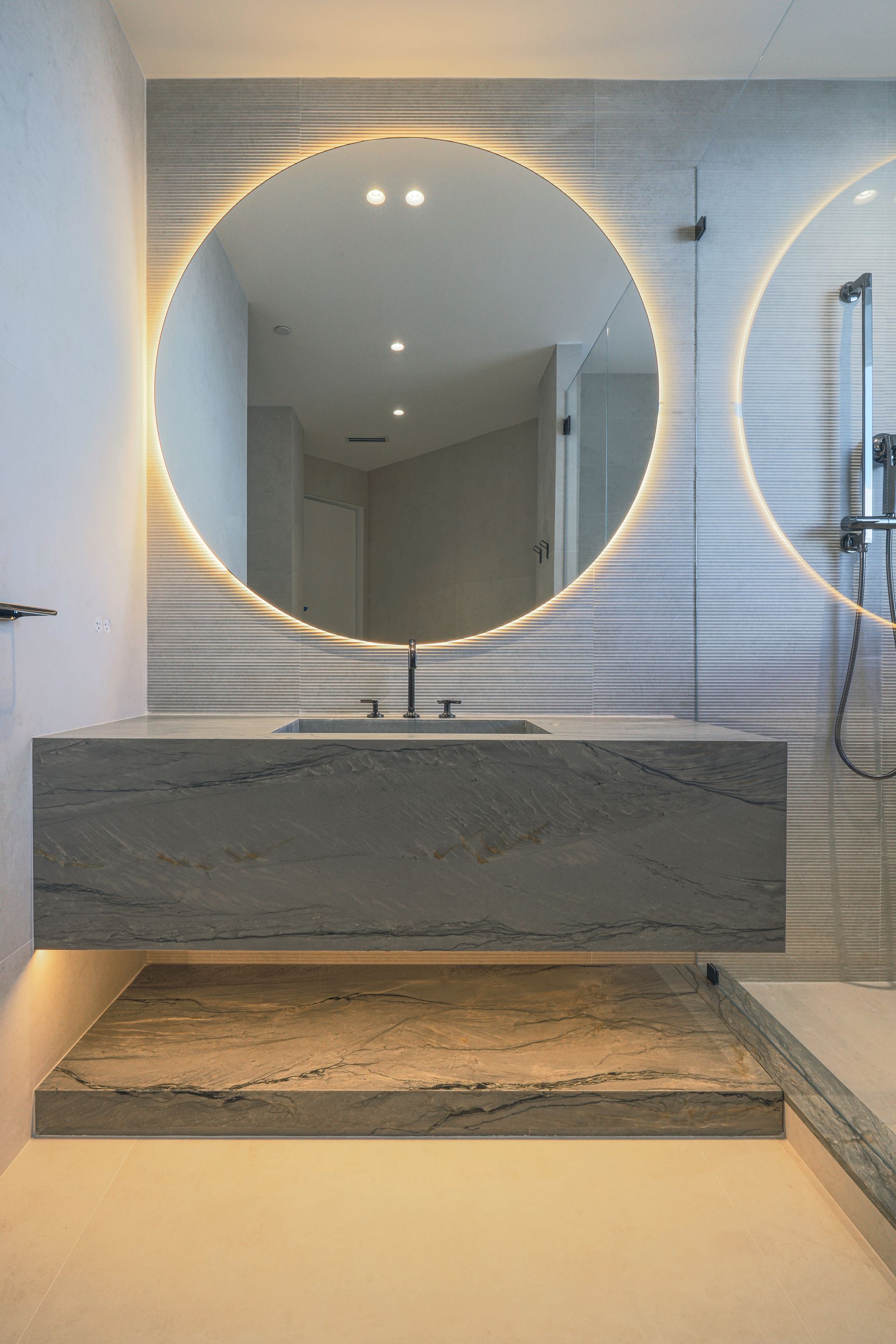 A bathroom with two round mirrors and a sink.