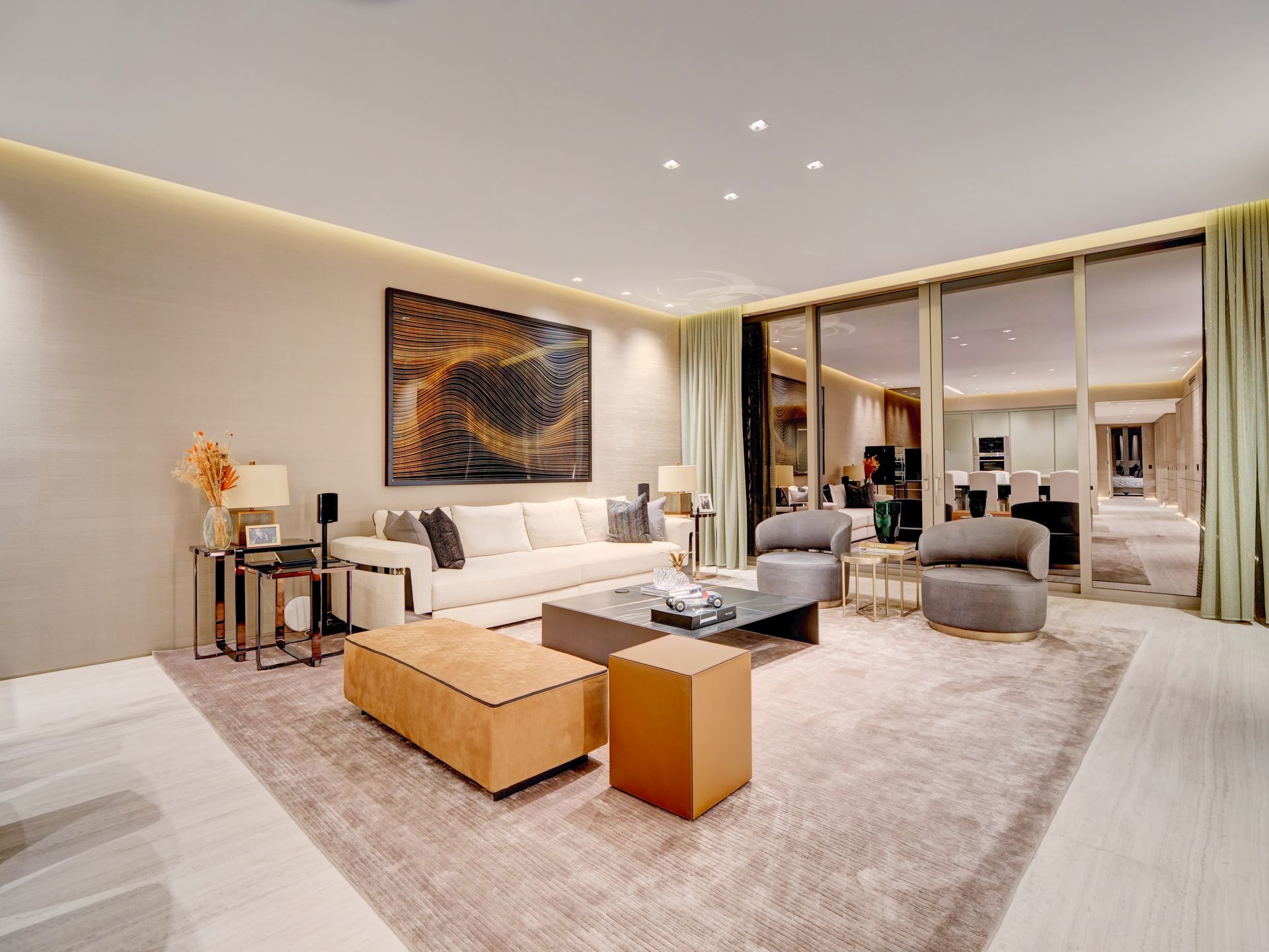 A living room with a couch , chairs , ottomans and a coffee table.