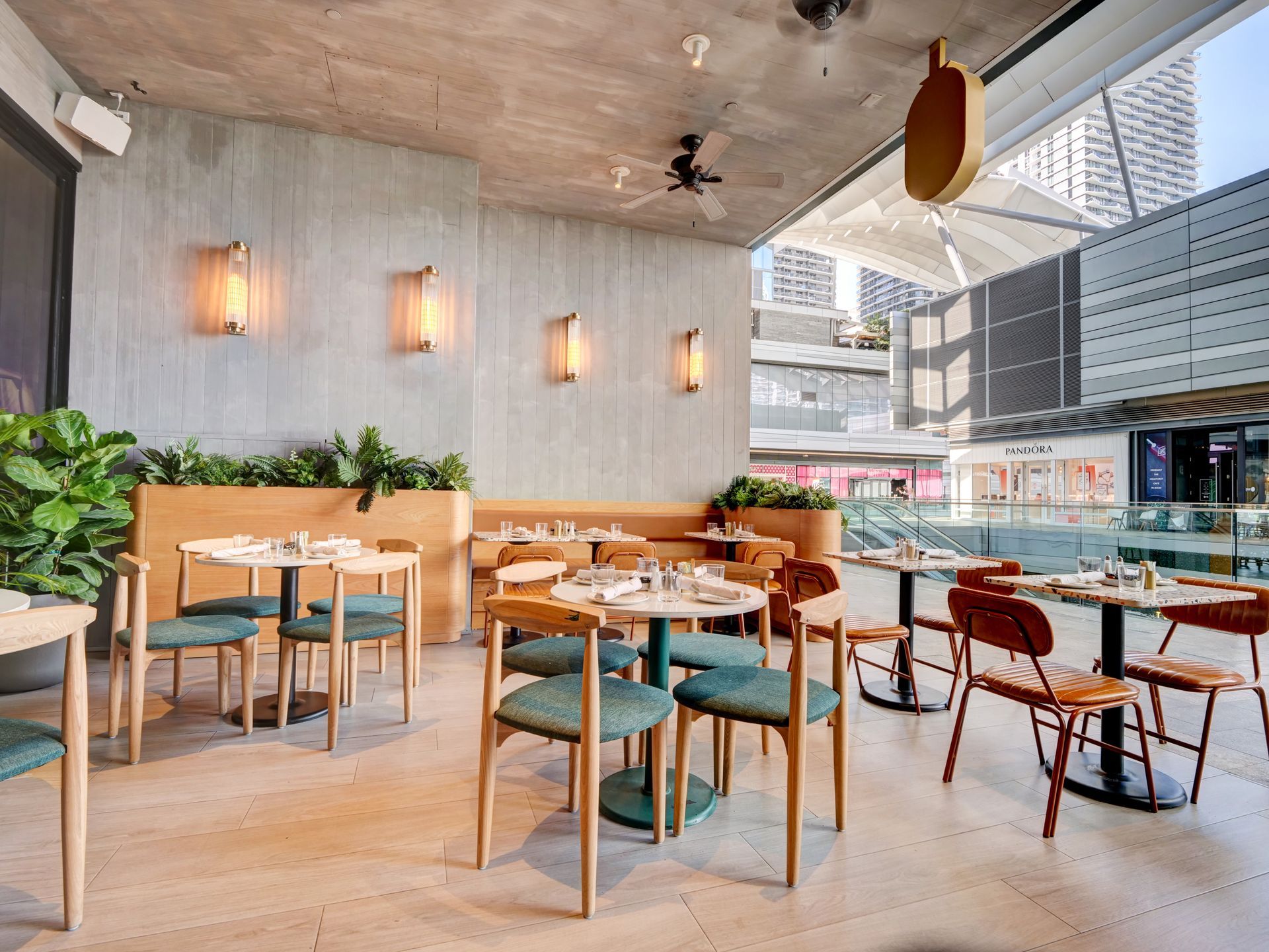 A restaurant with tables and chairs and a ceiling fan.
