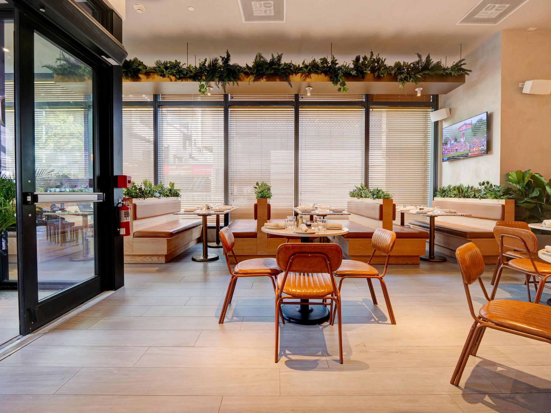 A restaurant with tables and chairs and a large window.