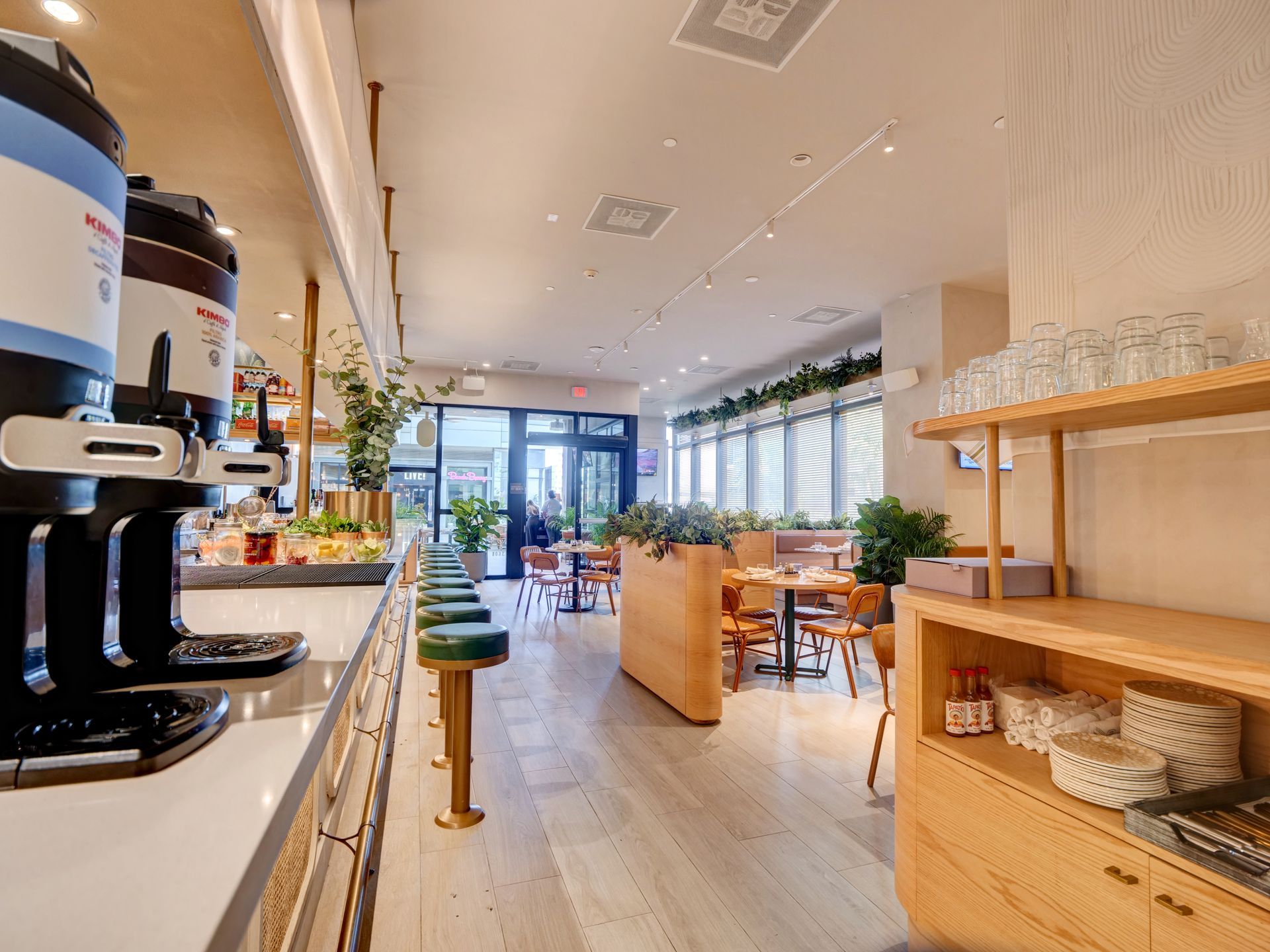 A restaurant with a lot of tables and chairs and a counter.