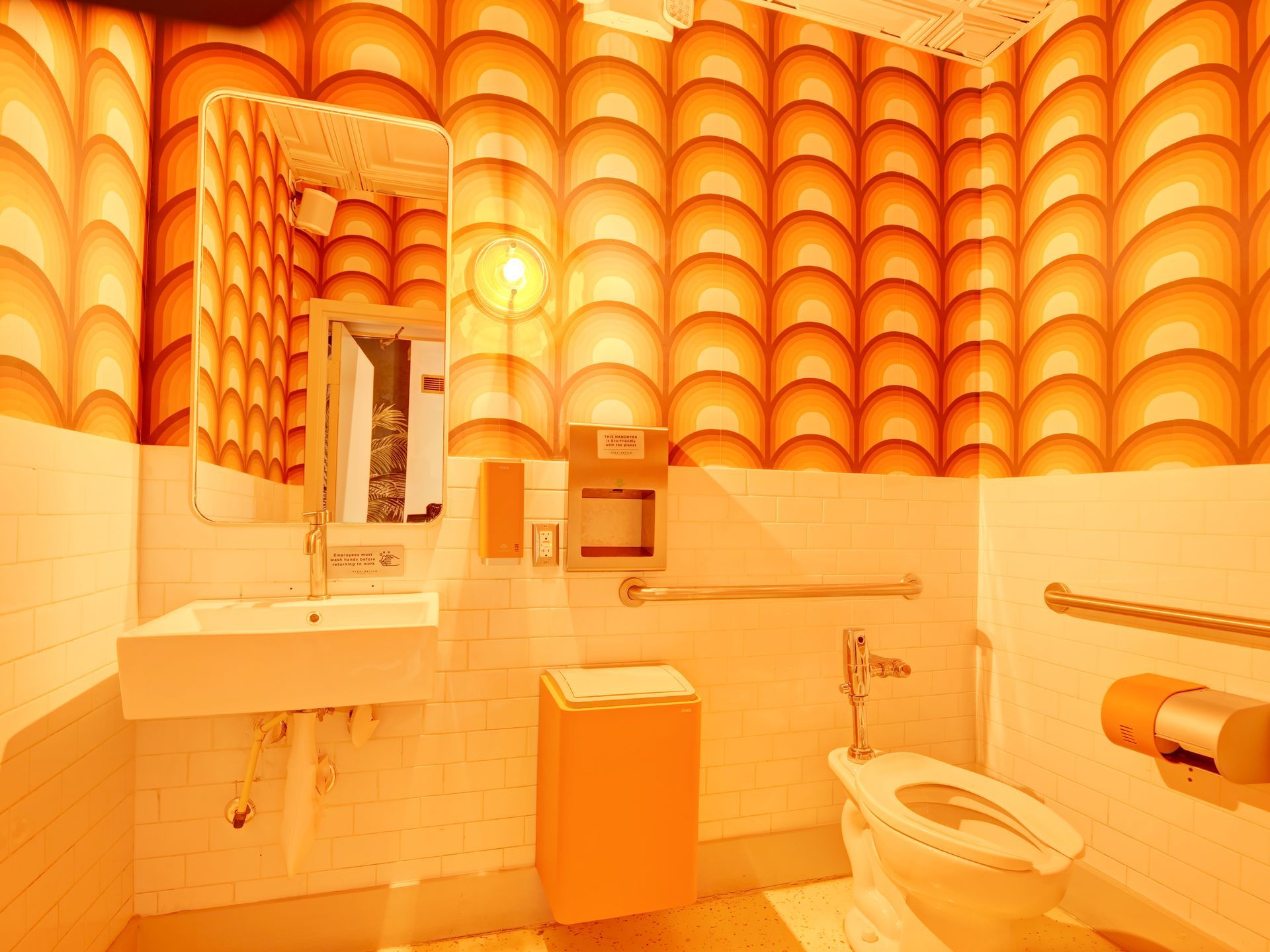 A bathroom with a toilet a sink and a mirror