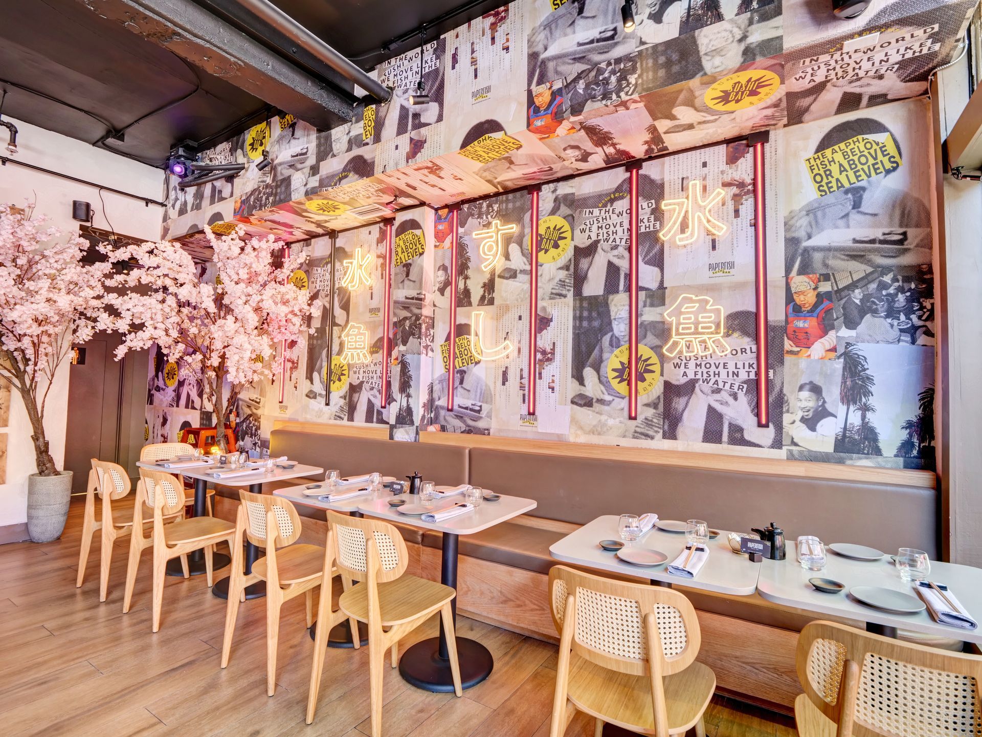 A restaurant with tables and chairs and a mural on the wall.