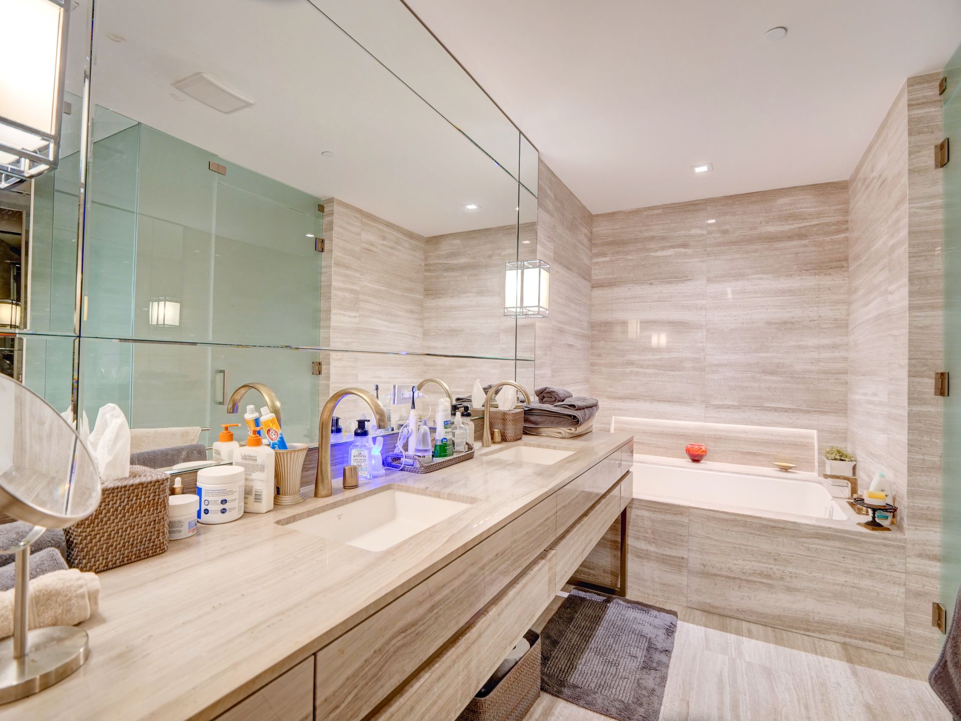 A bathroom with two sinks , a tub and a mirror.