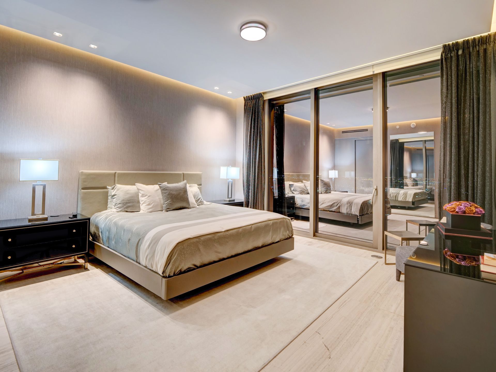 A bedroom with a king size bed and sliding glass doors.