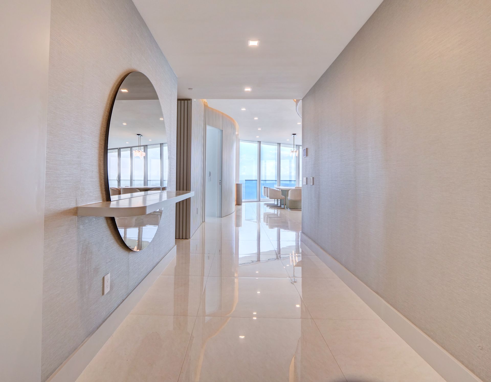 A long hallway with a round mirror on the wall