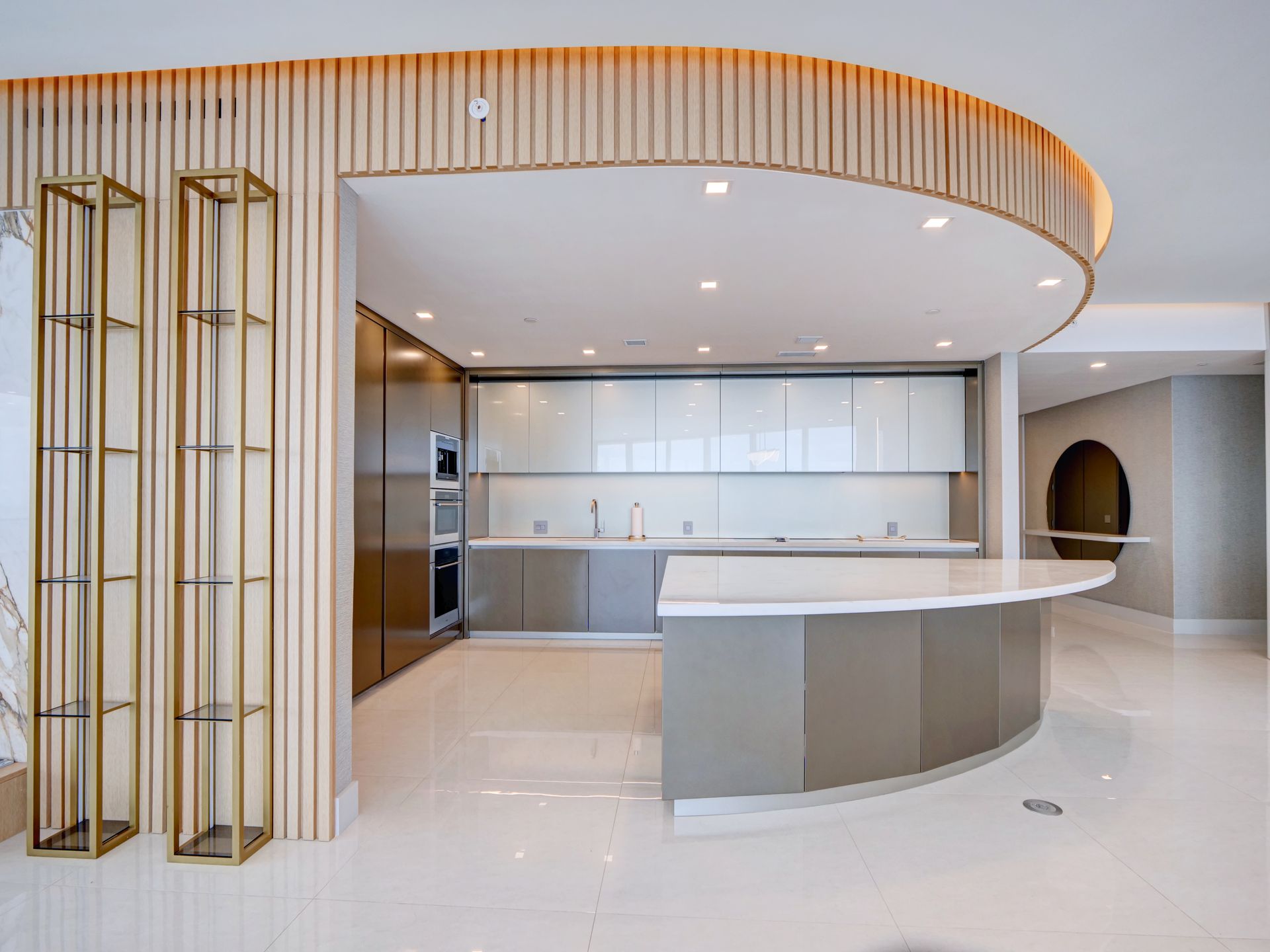 A kitchen with a curved ceiling and a large island in the middle.