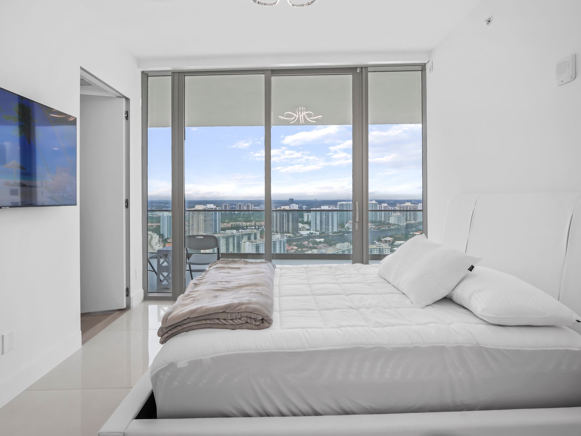 A bedroom with a large bed and a large window