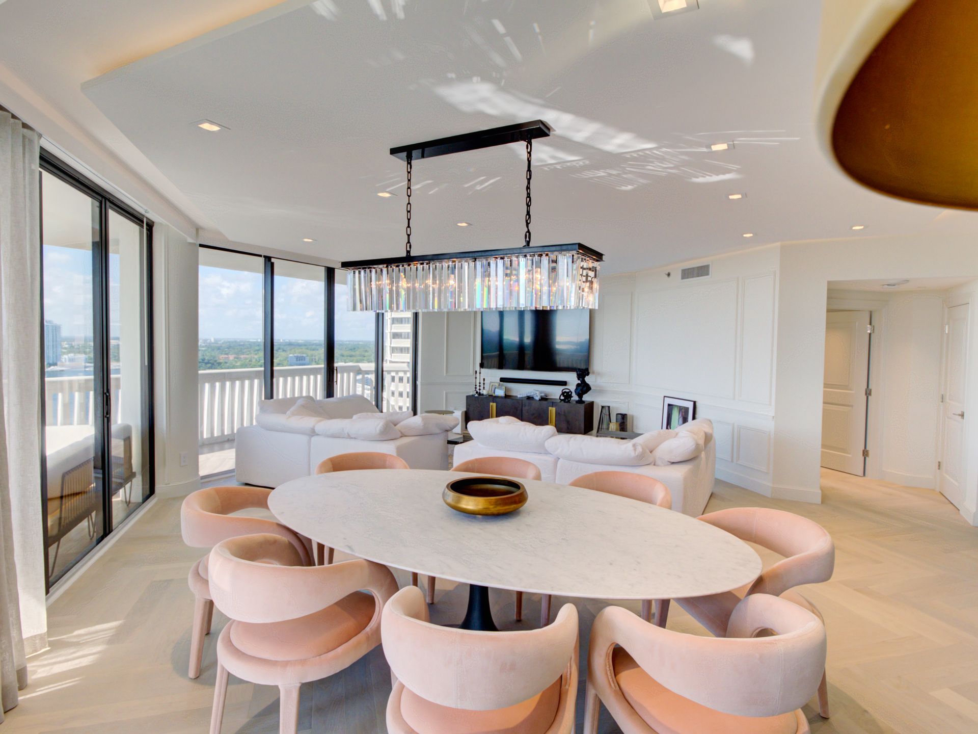 A dining room with a table and chairs and a chandelier hanging from the ceiling.