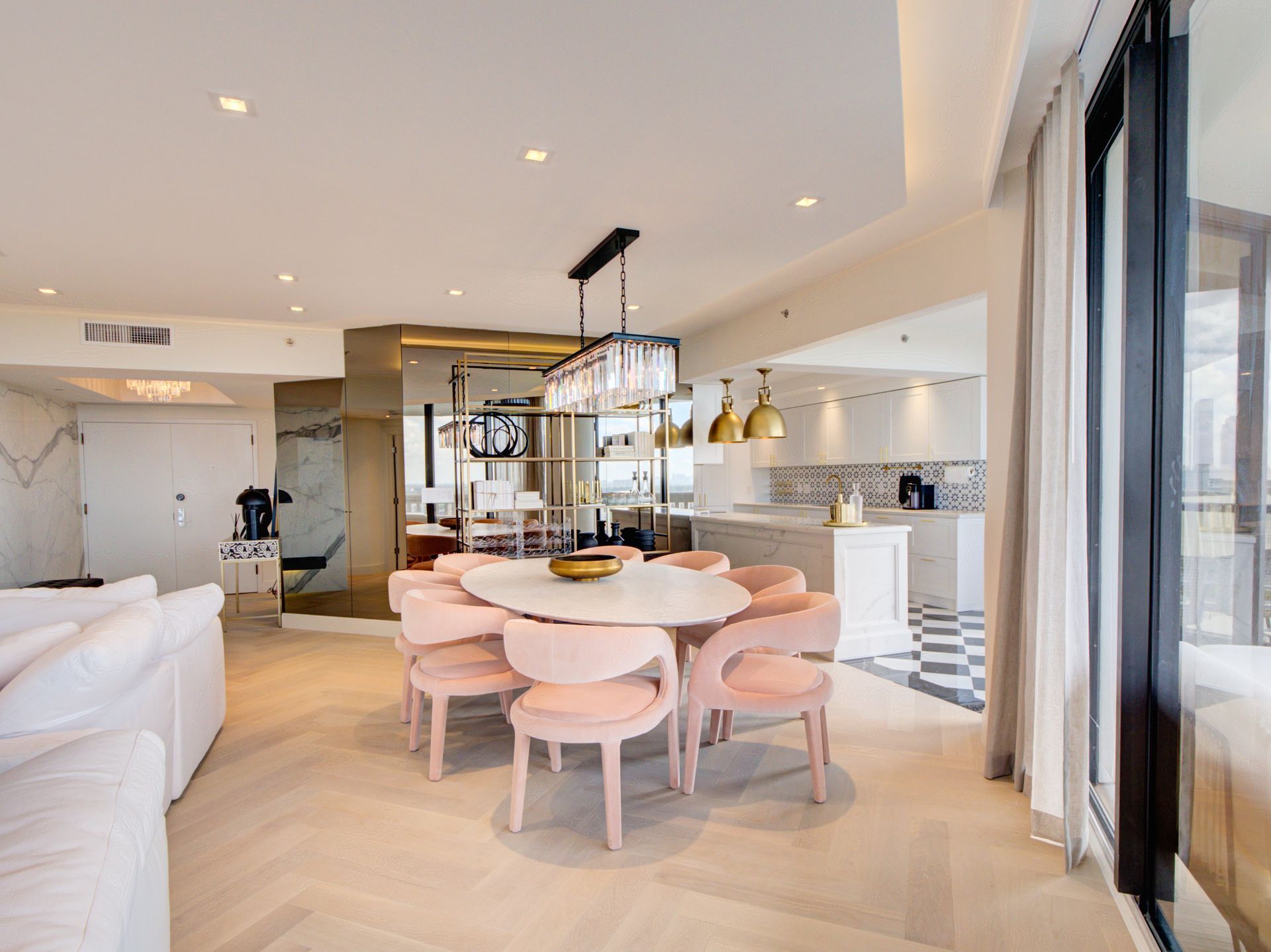 A living room with a dining table and chairs and a kitchen.