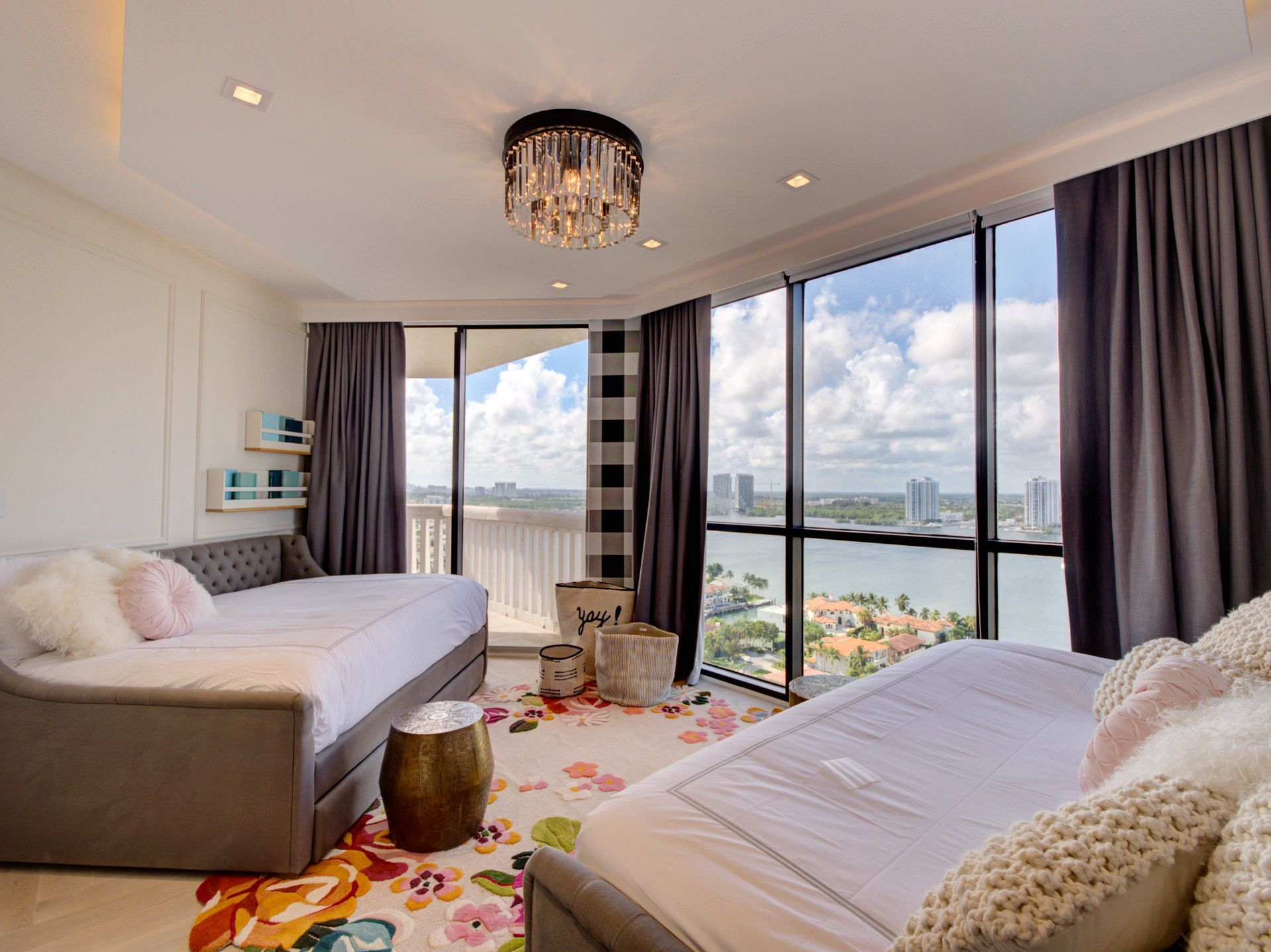 A bedroom with two beds , a couch , and a large window.