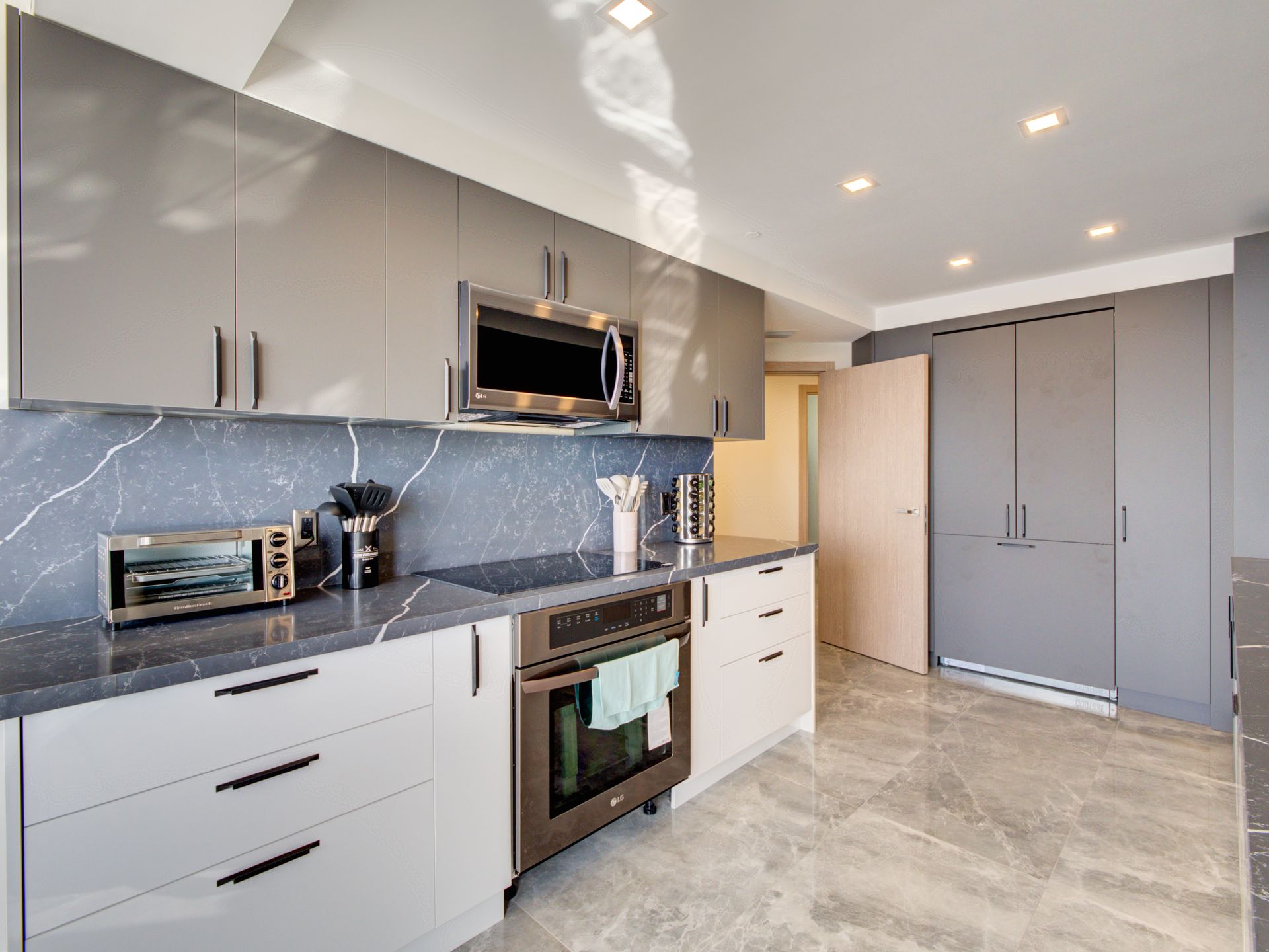 A kitchen with white cabinets and stainless steel appliances