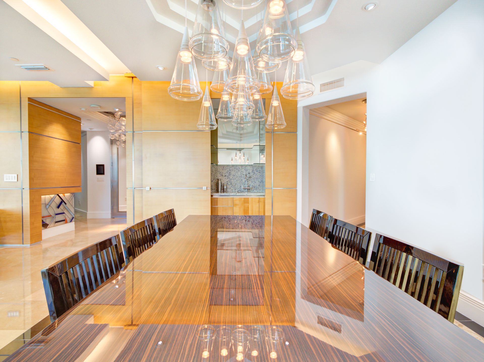 A dining room with a long table and chairs and a chandelier