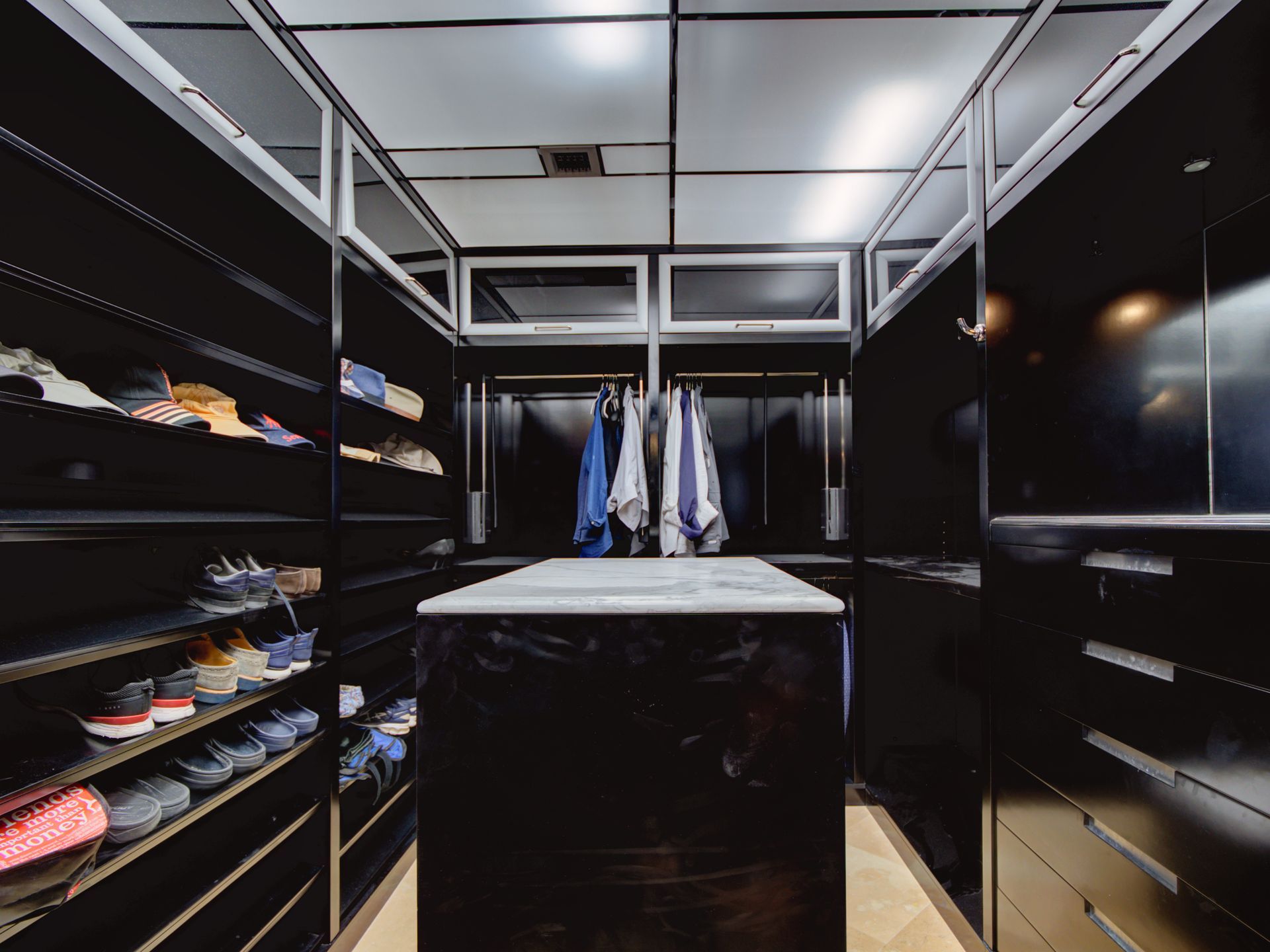A walk in closet with lots of shoes on shelves
