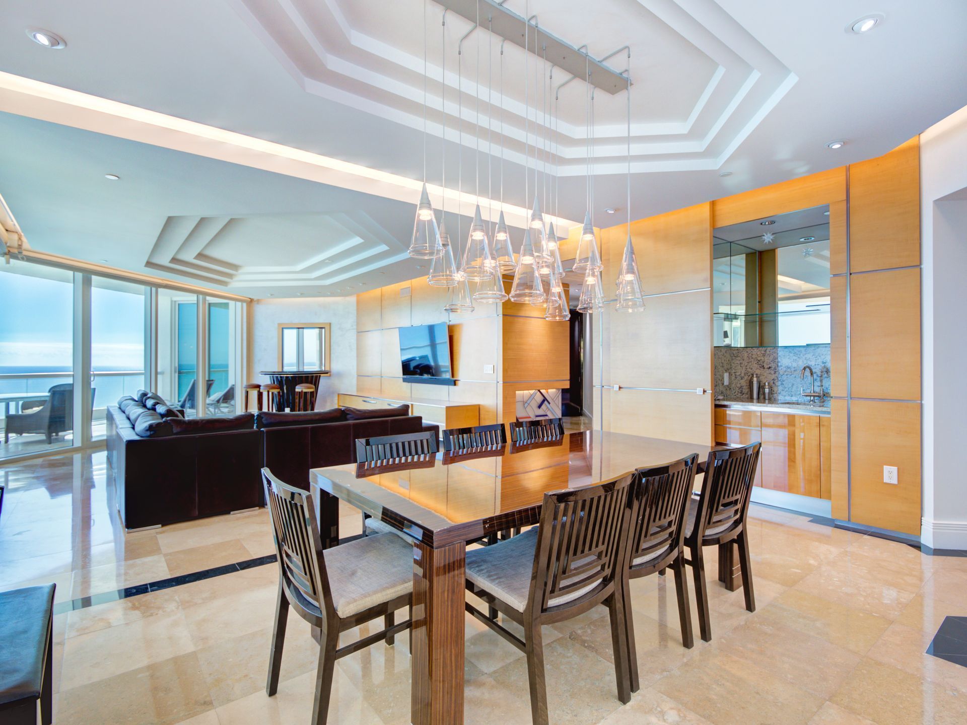 A large dining room with a table and chairs and a chandelier hanging from the ceiling.