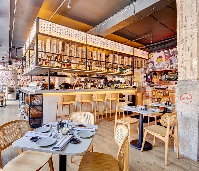 A restaurant with tables and chairs and a bar.